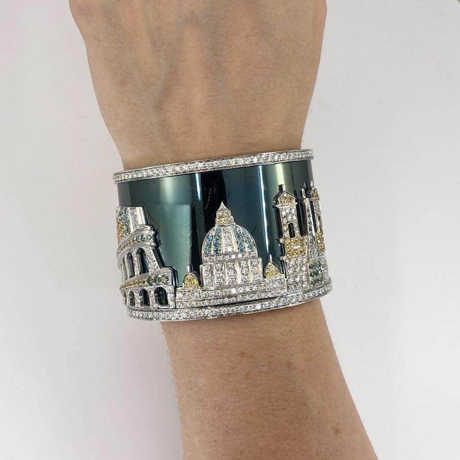 Contemporary Roman Vista Diamond Sapphire Cuff Bracelet in 18k white gold.

A gorgeous vista of Rome is depicted in this wide cuff bracelet, featuring round brilliant white diamonds with multi-colored sapphires in tones of blue, green, and yellow.
