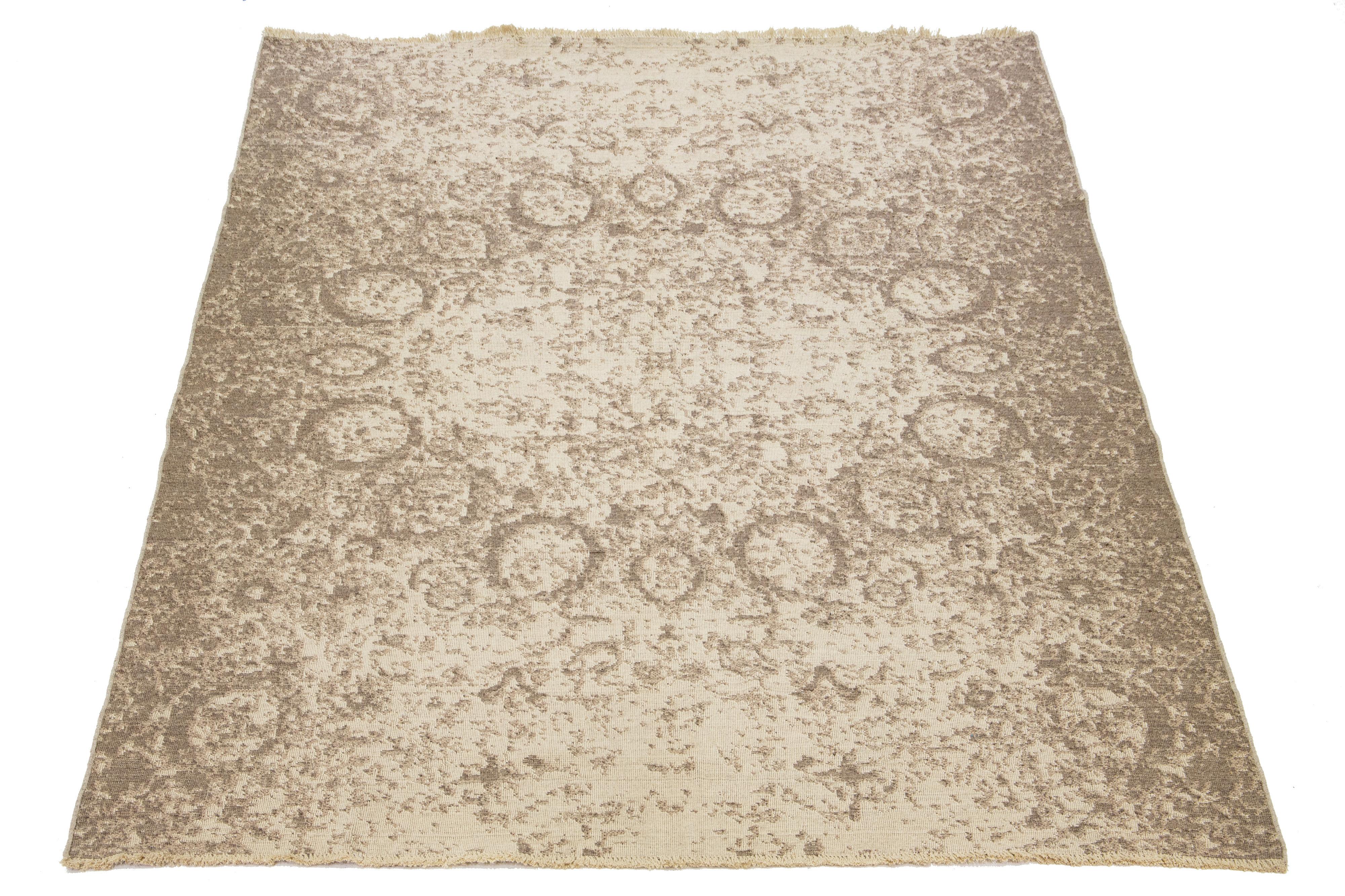 This hand-loomed wool rug boasts a stunning beige background that perfectly complements the striking gray all-over design. It's a must-have for anyone who wants to elevate their home decor game.

This rug measures 9'6