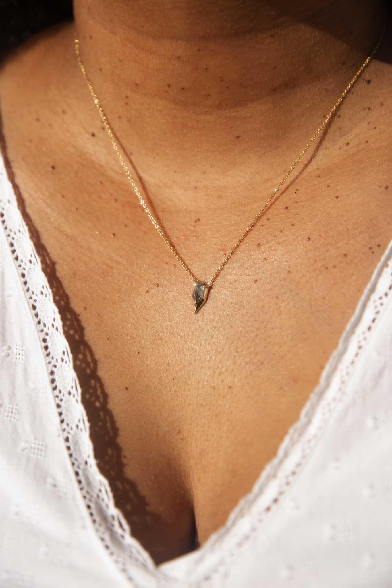 For the one who welcomes eccentricity and walks their own path. Crafted in 9 carat gold, The Ria Necklace is an intriguing piece. Her salt and pepper shield cut diamond is set in a sharp arrowhead of polished gold and unafraid of her imperfections,