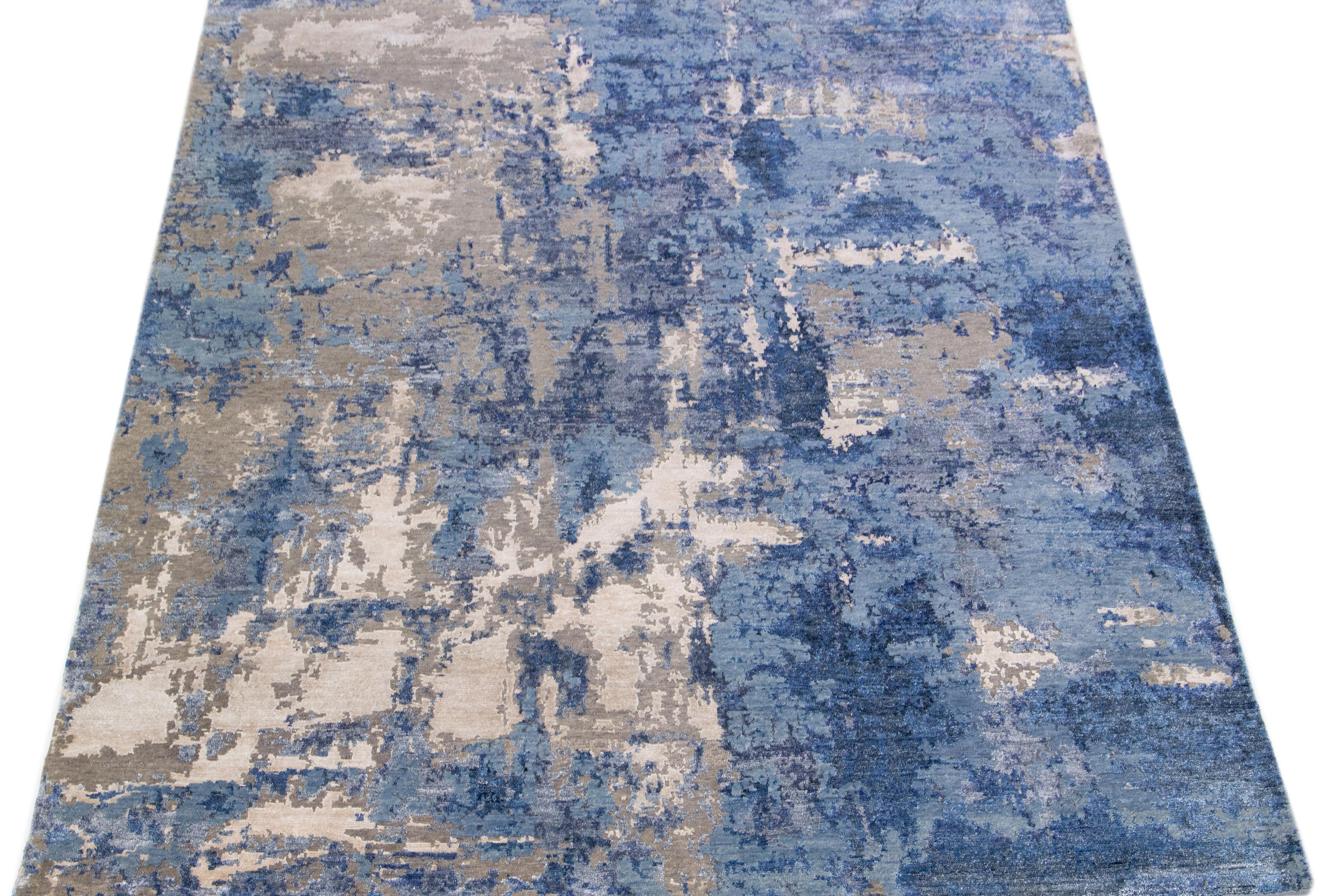 This Indian wool and silk blend rug features a blue field with an abstract pattern detailing brown and beige colors. Its composed materials provide robustness and longevity, while its ornamental design infuses any room with sophistication.

This