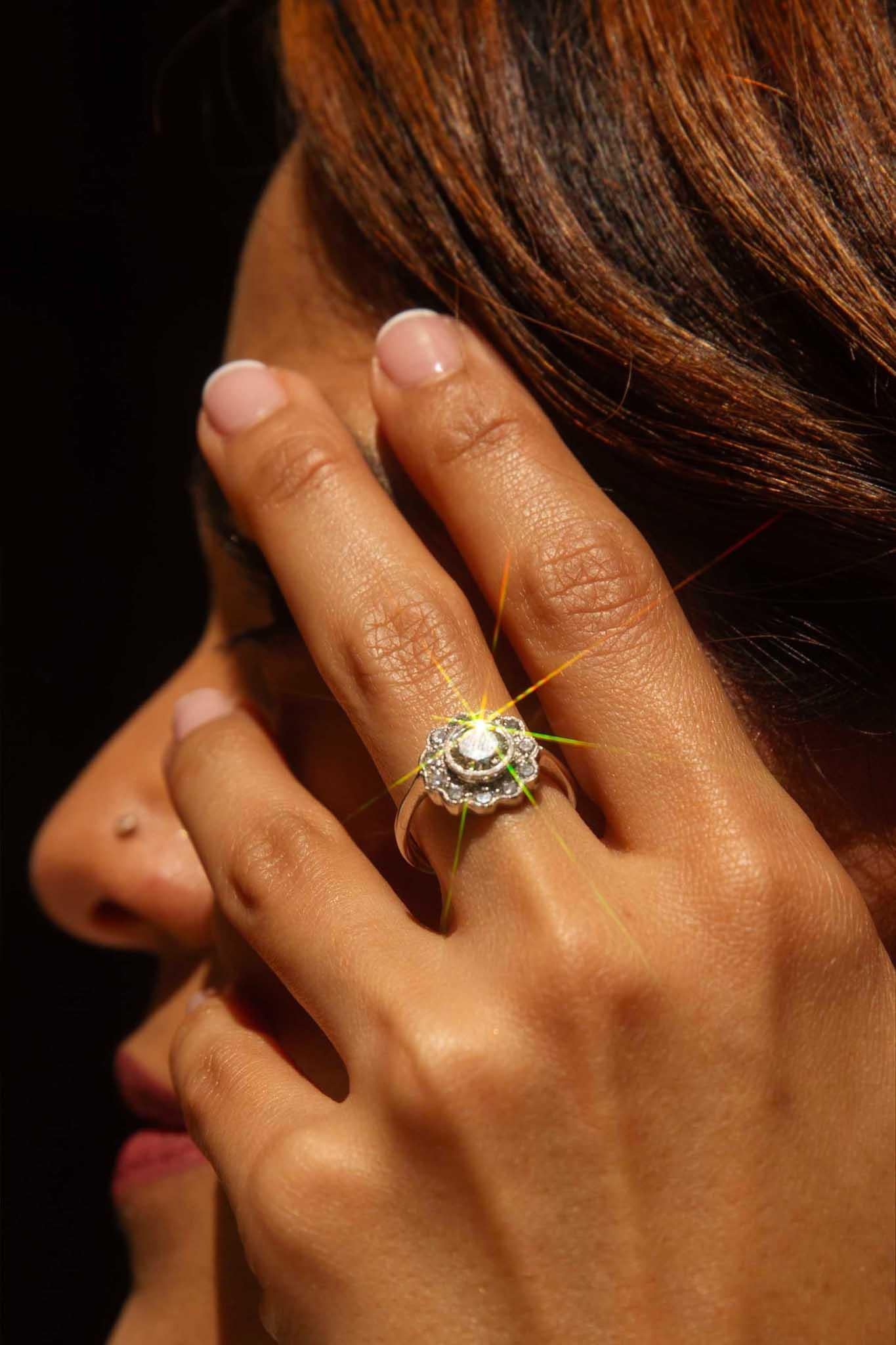 The Wallace Ring is a design marvel, symbolizing deep intentions. Her central diamond, akin to a daisy's heart, sparkles like morning dew. Surrounding it, a halo of fine diamond petals forms an enchanting motif, evoking the image of a blossoming
