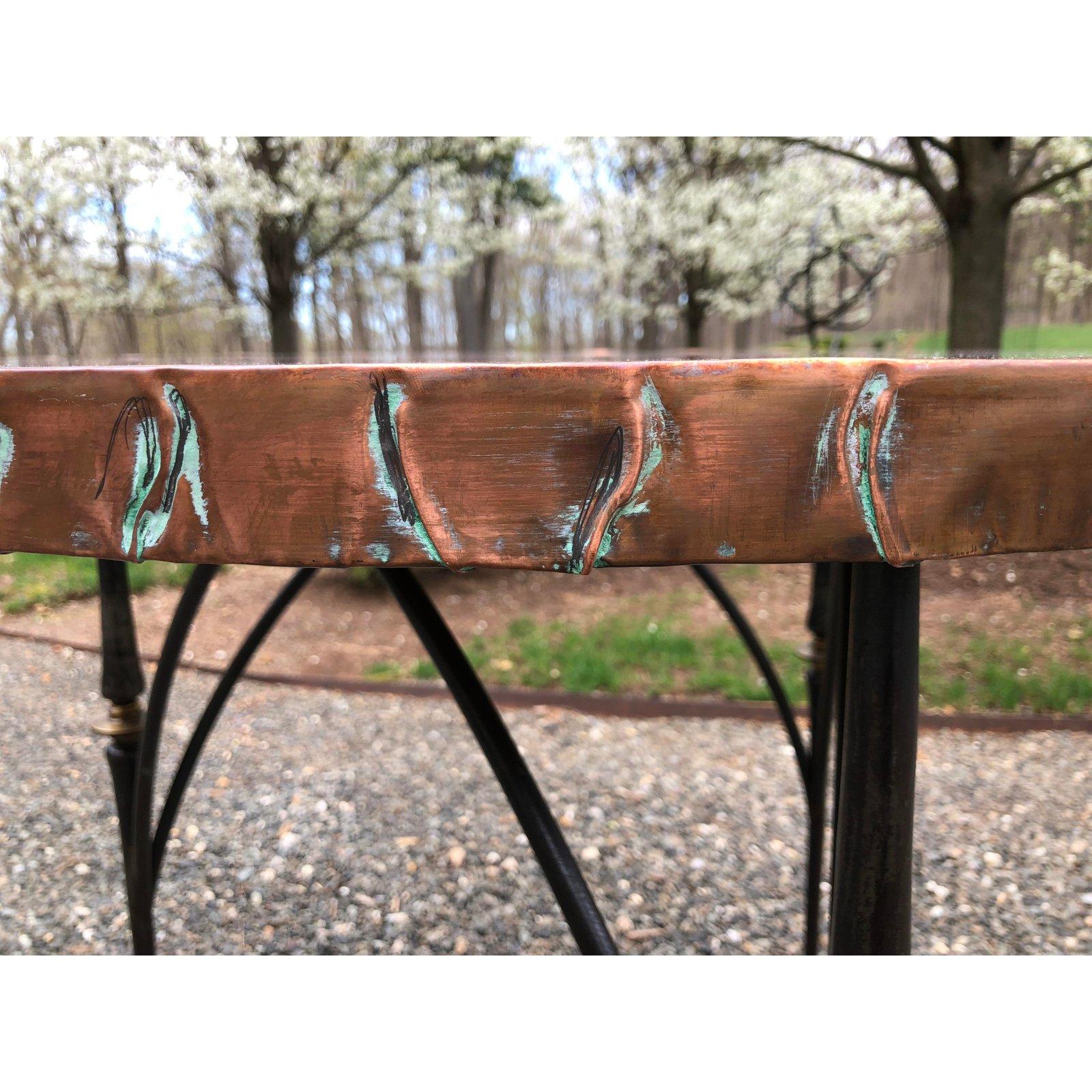 Stunning center or small dining table with a hammered copper top. Copper is not lacquered, so acquires a wonderful patina with use. The base is comprised of three sculptural iron legs in the style of Giacometti.
Two available.