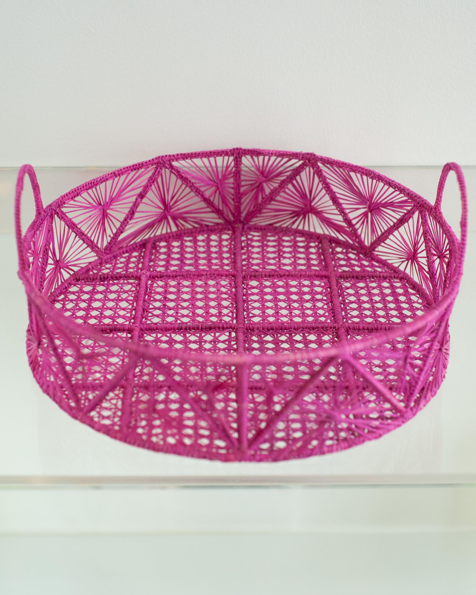 Verschönern Sie Ihren Tisch mit diesem atemberaubenden runden, handgeflochtenen Rattankorb / Tablett in Hot Pink. Dieses von erfahrenen Kunsthandwerkern gefertigte Stück zeigt die klassische Technik des Webens auf moderne Weise. Von Jean Michel