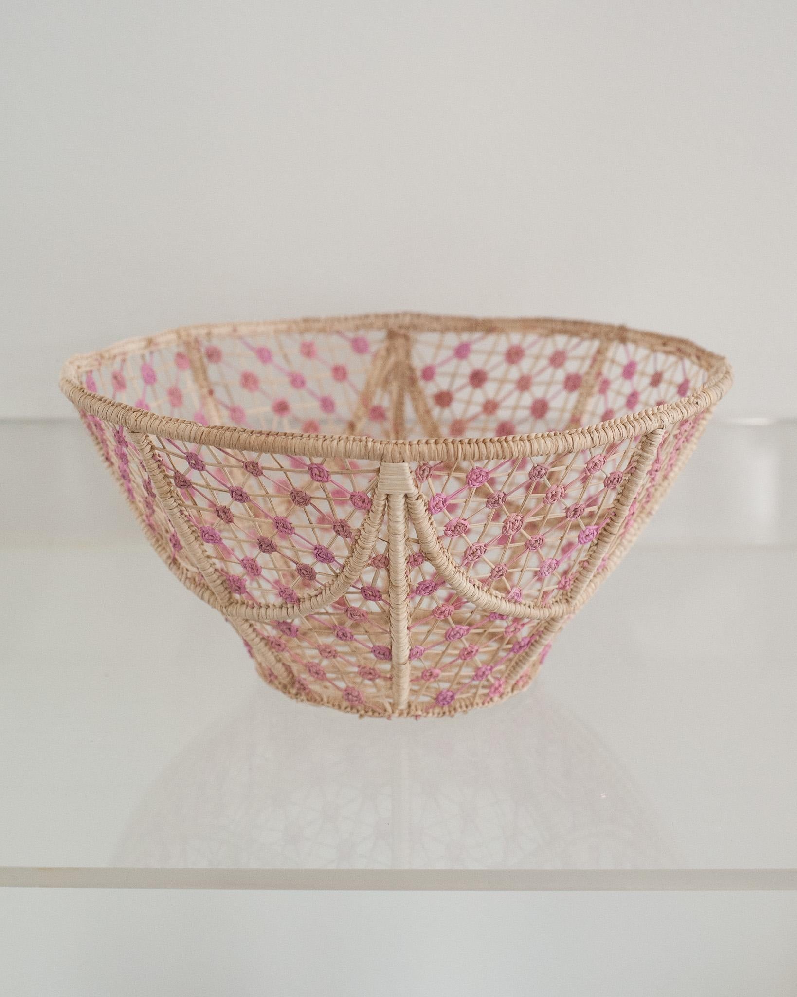 Ravviva la tua tavola con questa splendida ciotola rotonda in rattan intrecciato a mano con morbidi nodi rosa. Finemente realizzato da esperti artigiani, questo pezzo mette in mostra la tecnica classica della tessitura in chiave moderna. Da Jean