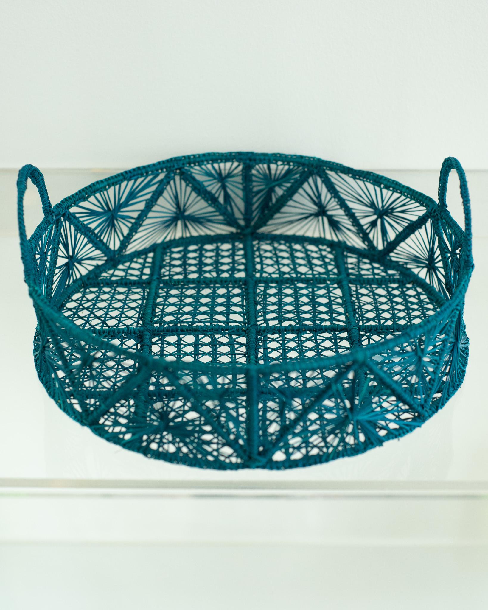 Verschönern Sie Ihren Tisch mit diesem wunderschönen runden, handgeflochtenen Rattankorb / Tablett in Türkis. Dieses von erfahrenen Kunsthandwerkern gefertigte Stück zeigt die klassische Technik des Webens auf moderne Weise. Von Jean Michel Frank