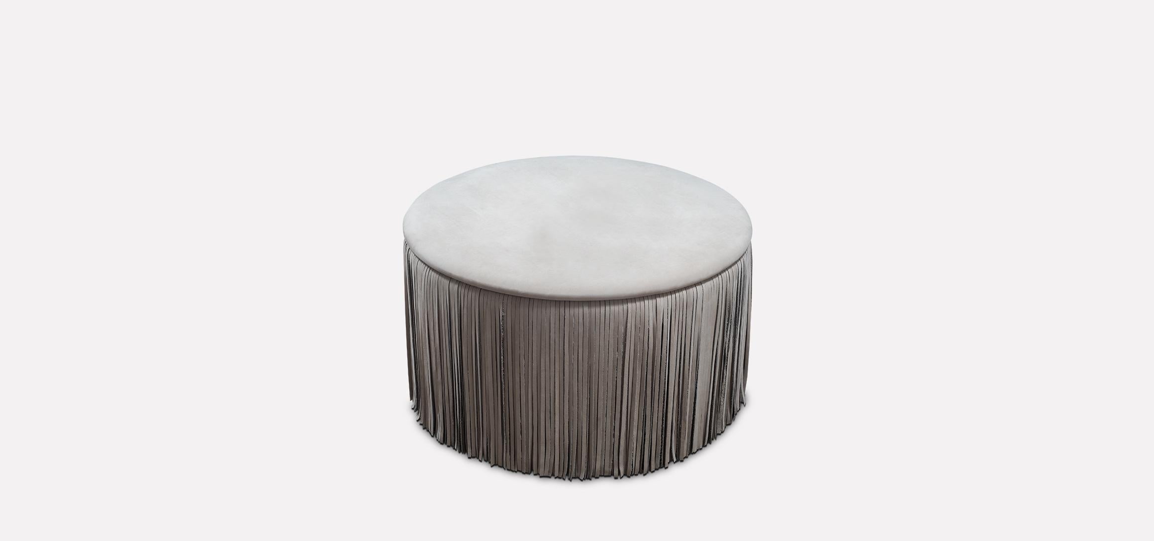 The TAGLIA round leather ottoman introduces the timeless fashion element of fringes to haute furniture design. This little playful round ottoman with a curved seat is surrounded by a dense skirt of nubuck leather fringes and provides your living