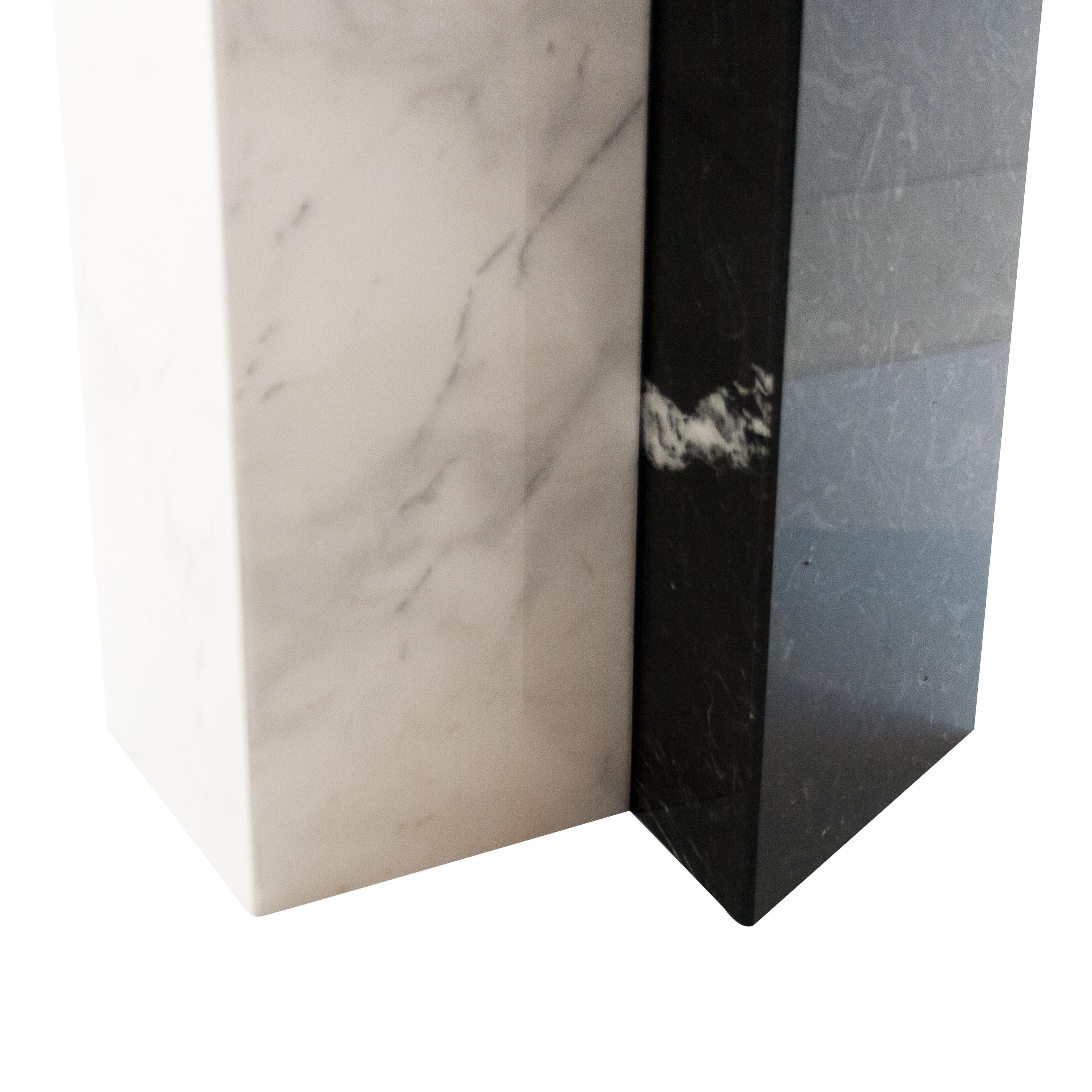 Table basse conçue par IKB191, de forme arrondie. Structure composée d'un prisme carré en marbre blanc de Carrare et d'un prisme triangulaire en marbre noir de Marquina. Le plateau est également en marbre blanc de Carrare.