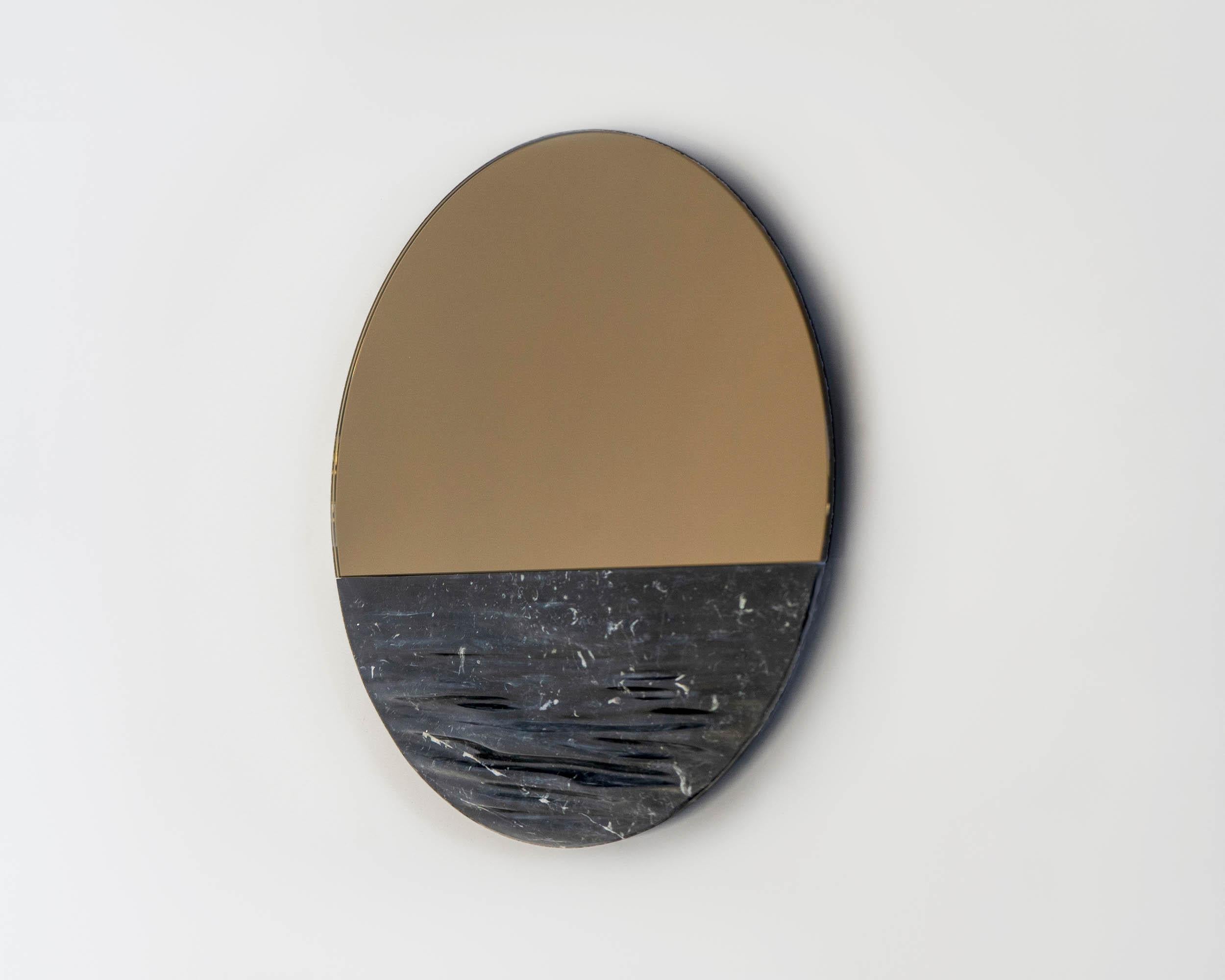 Orizon Blacksea
Round mirror signed by Ocrùm 

Dimensions: 31.5 x 1.75 in
Materials: Carved marble, glass mirror
Colors: Marquina black, bronze / gray mirror
Customization: Glass tint, frame finish and size are customizable at an additional