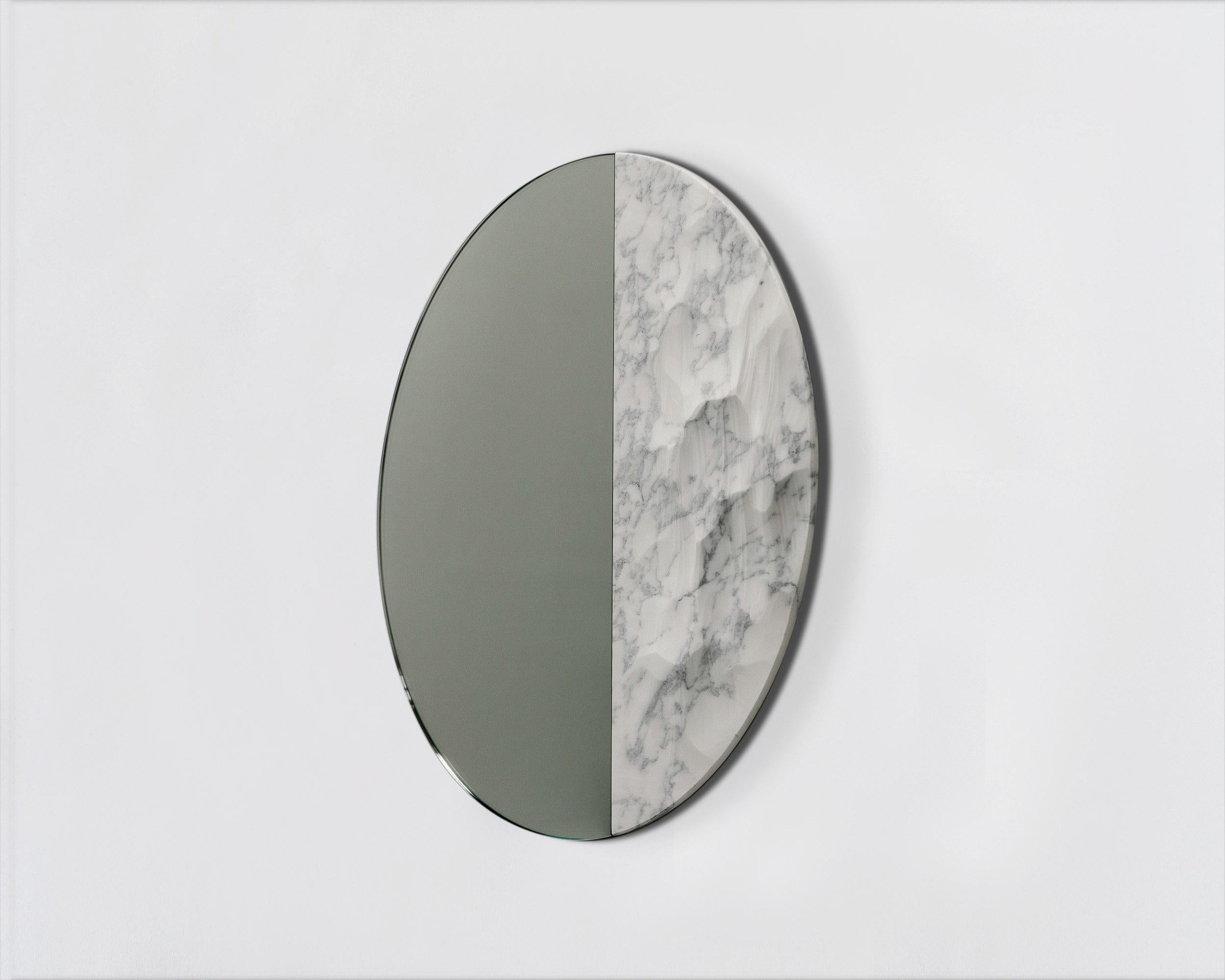 Snowmotion
Round mirror signed by Ocrùm 

Dimensions: 31.5 x 1.75 in
Materials: Carved marble and glass mirror
Colors: Liberty white and clear mirror
Customization: Glass tint, frame finish and size are customizable at an additional