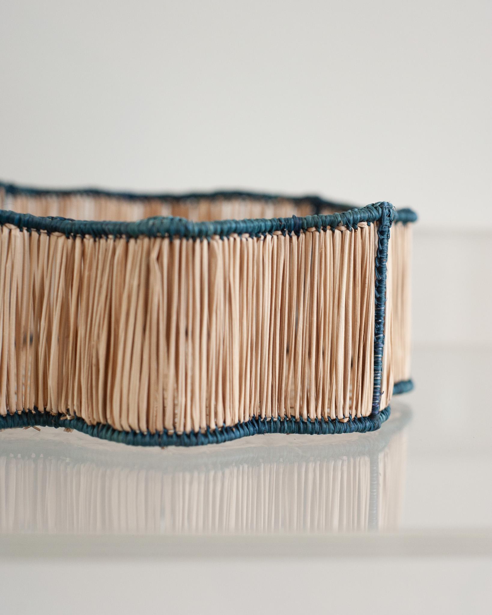 Rehaussez votre table avec ce superbe bol / panier à pain ondulé en rotin tressé à la main. Finement élaborée par des artisans experts, cette pièce met en valeur la technique classique du tissage d'une manière moderne. De Jean Michel Frank à la