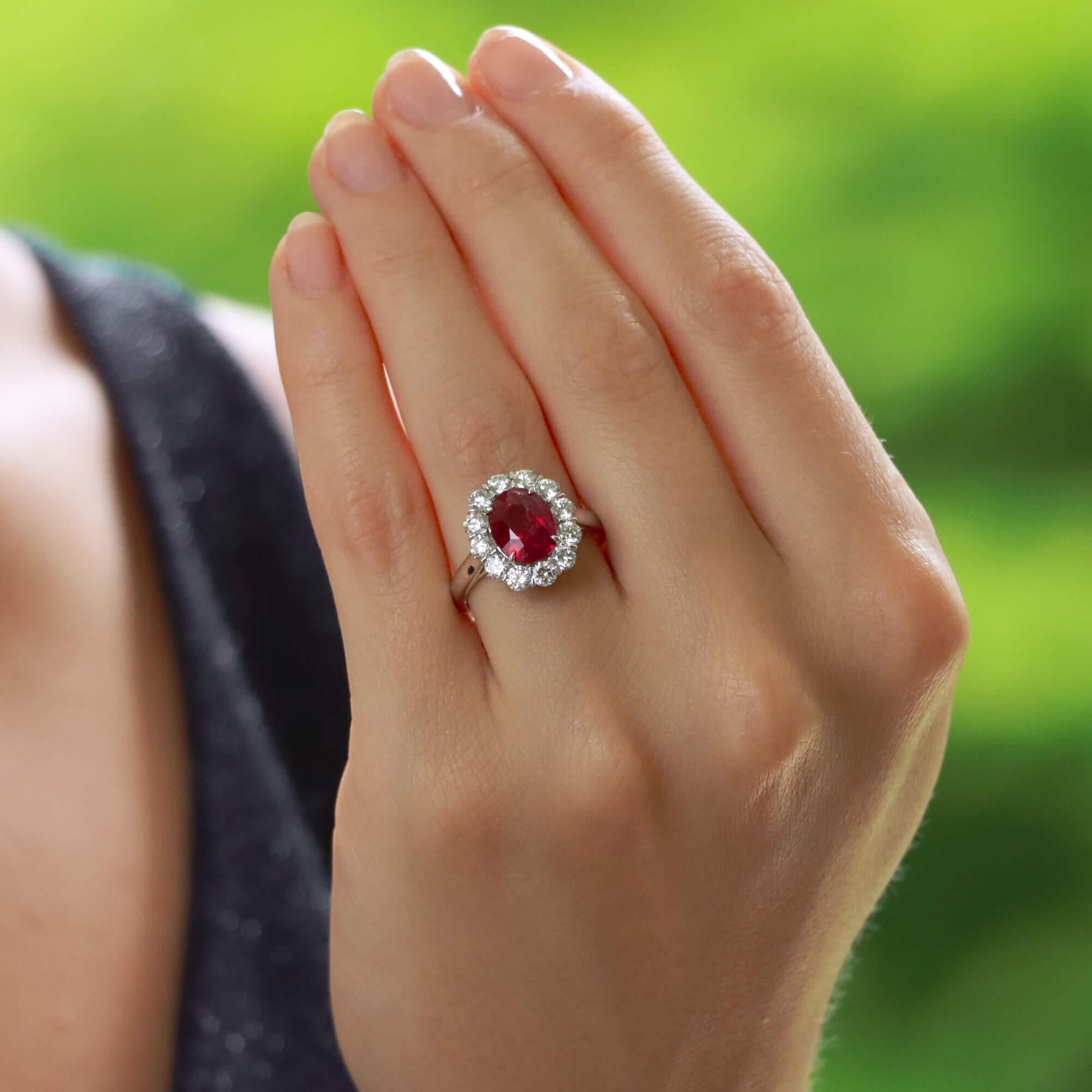 A truly stunning ruby and diamond cluster ring set in platinum.

The piece is centrally set with an astounding 2.94 carat oval cut ruby which is four claw set. The ruby has a fantastic vibrancy to it and is surrounded by a cluster of 12 round