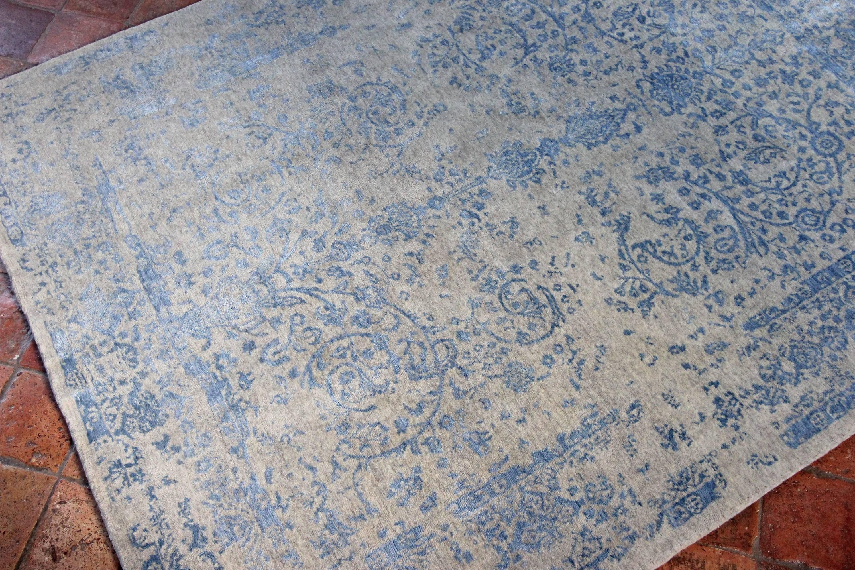 This contemporary rug is sky blue in color and the woven with lovely silk highlights. The background of the carpet is all natural wool and the woven design is all silk, giving a wonderful texture to the piece. The design is taken from antique rugs