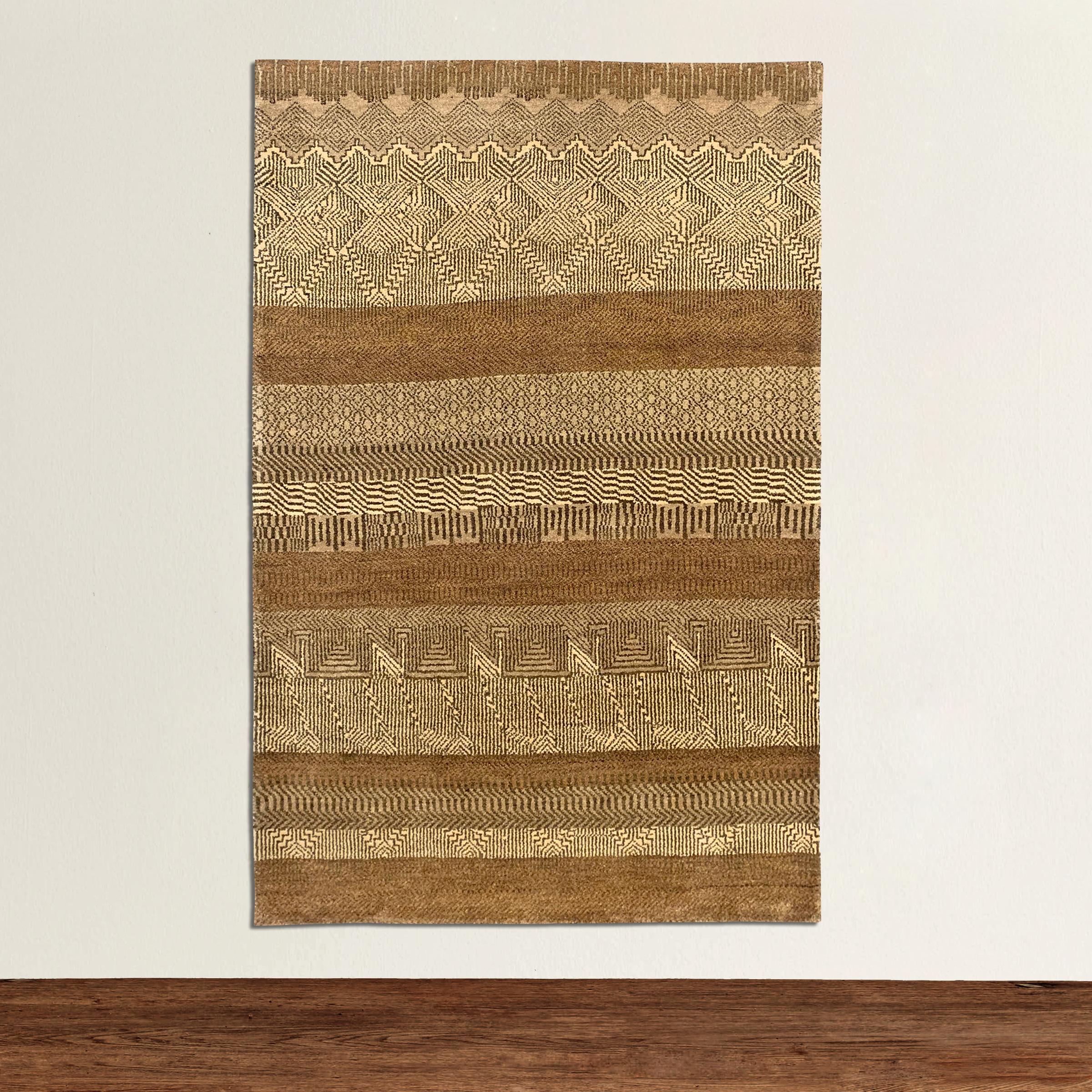 A wonderful contemporary Indian handwoven wool rug with a tribal pattern containing myriad geometric patterns and stripes woven in varying shades of brown, cream, and taupe.