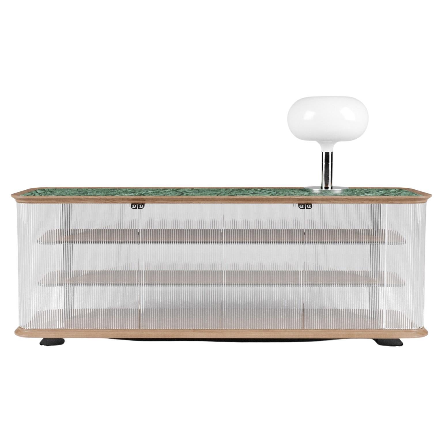 Nemesi #1 is a sideboard, designed by Sagaría.

The clean geometry and the authentic eloquence of the material, the fluted glass mixed with the honed Guatemala marble, are the intrinsic feature that underlines the sinuous, plastic shapes of Nemesi