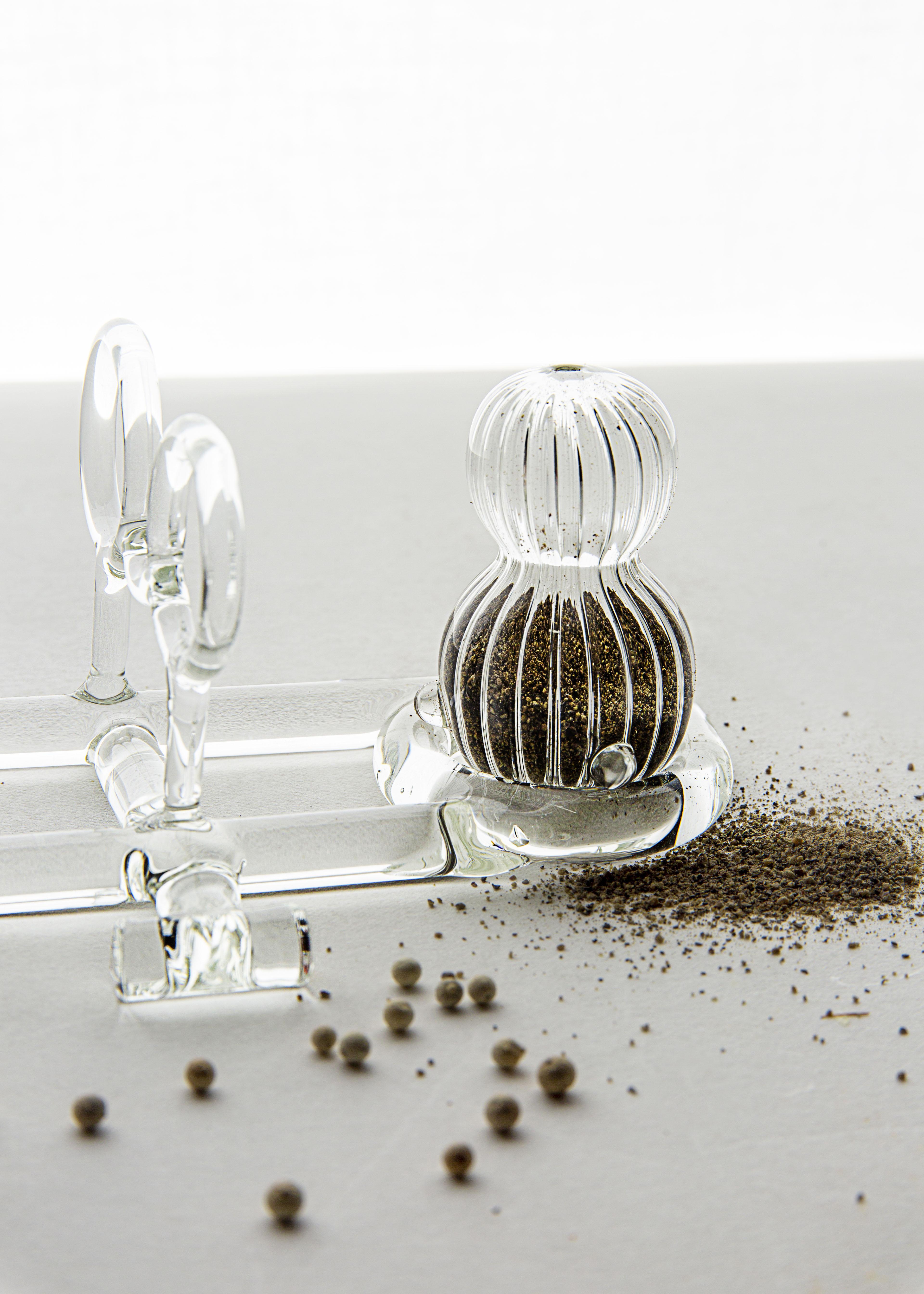 Salt and Pepper shaker from SiO2 Tableware collection 

Small Salt and Pepper shakers in striped glass that can be settled in their graceful base
with handle. 
Part of the SiO2 tableware collection, it has an aesthetic linked to the world of