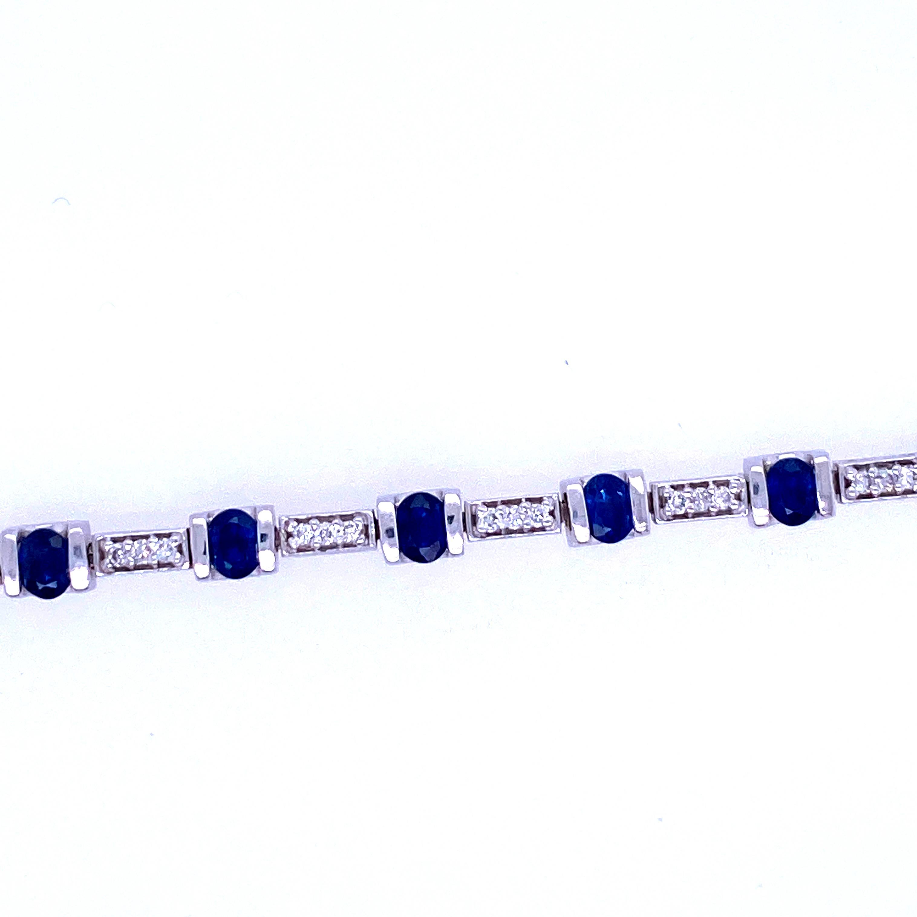 One 14 karat white gold (stamped BH 14K) sapphire and diamond bracelet bar set with 16 oval sapphires. 4x3 mm each, separated by 16 links, each bead set with three 1.5mm round brilliant diamonds, approximately 0.75 carats total weight with matching