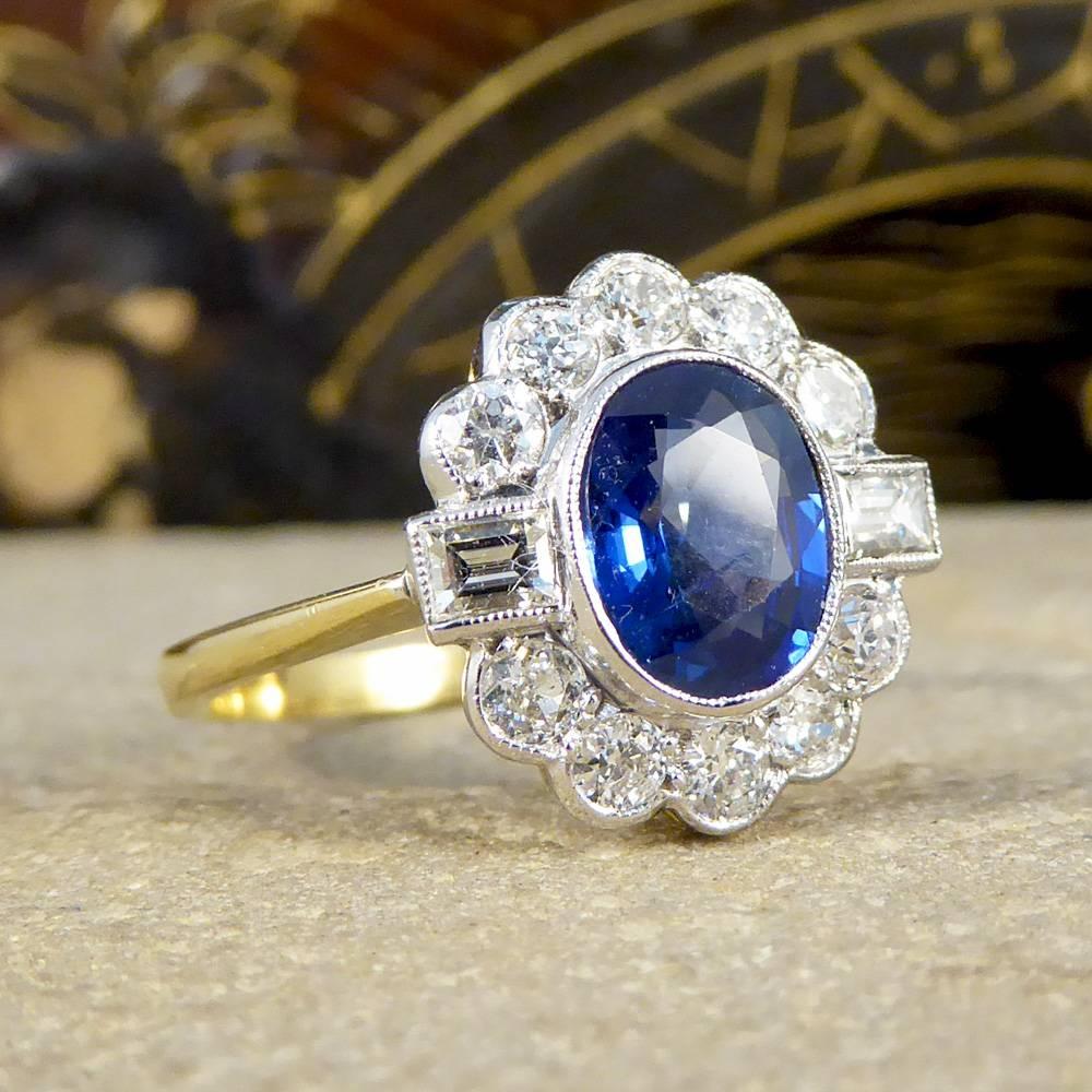 This contemporary Ring has been crafted to resemble an Art Deco style ring. A 1.50ct dazzling blue Sapphire in the centre of the ring and surrounded by a halo of 8 European cut Diamonds, with two Baguette cut Diamonds to separate them in the middle