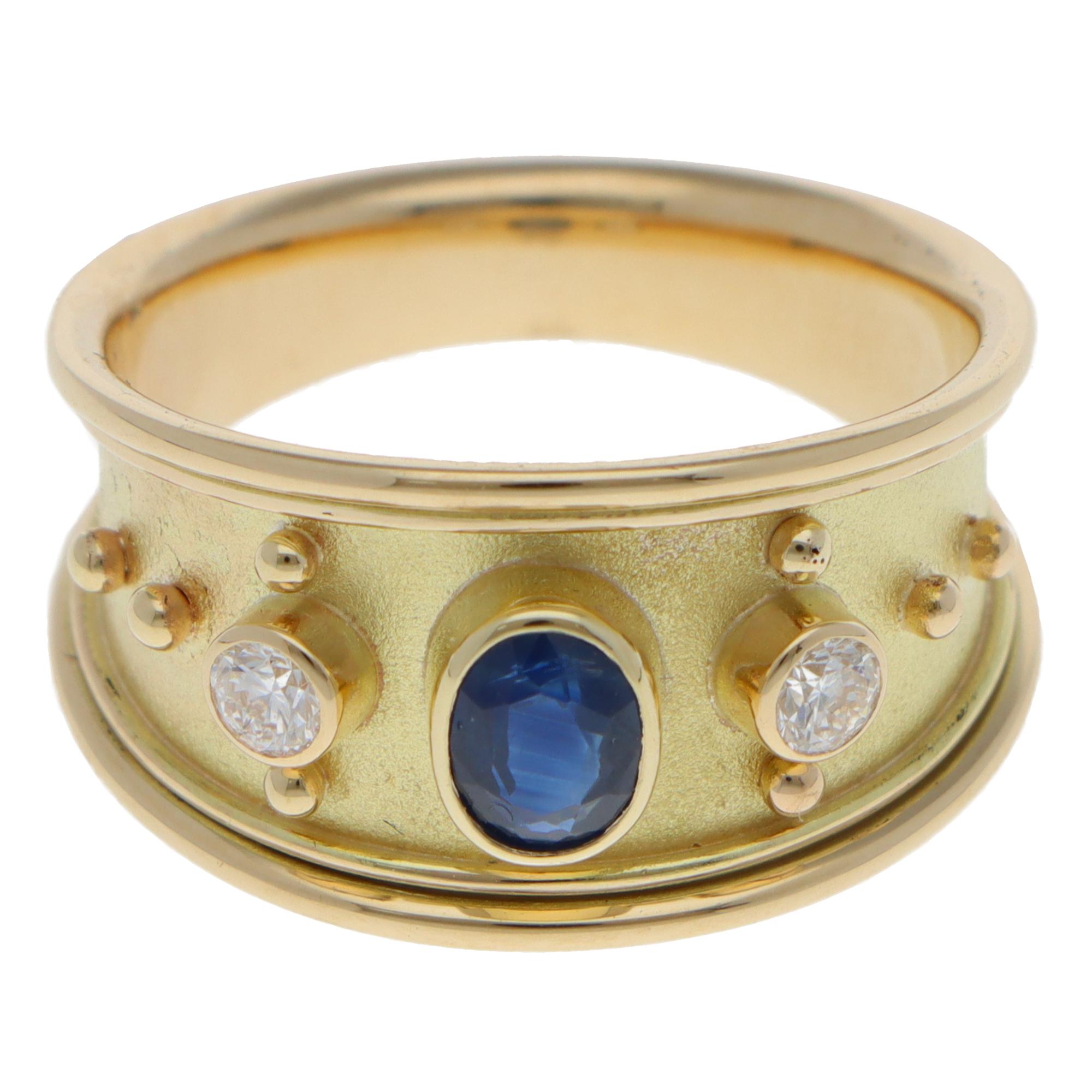 Magnifique bague contemporaine d'inspiration étrusque en saphir bleu et diamant, sertie en or jaune 9k.

La bague est sertie au centre d'un saphir bleu ovale de taille mixte, qui est serti dans une monture ouverte surélevée. Sur le côté du saphir,