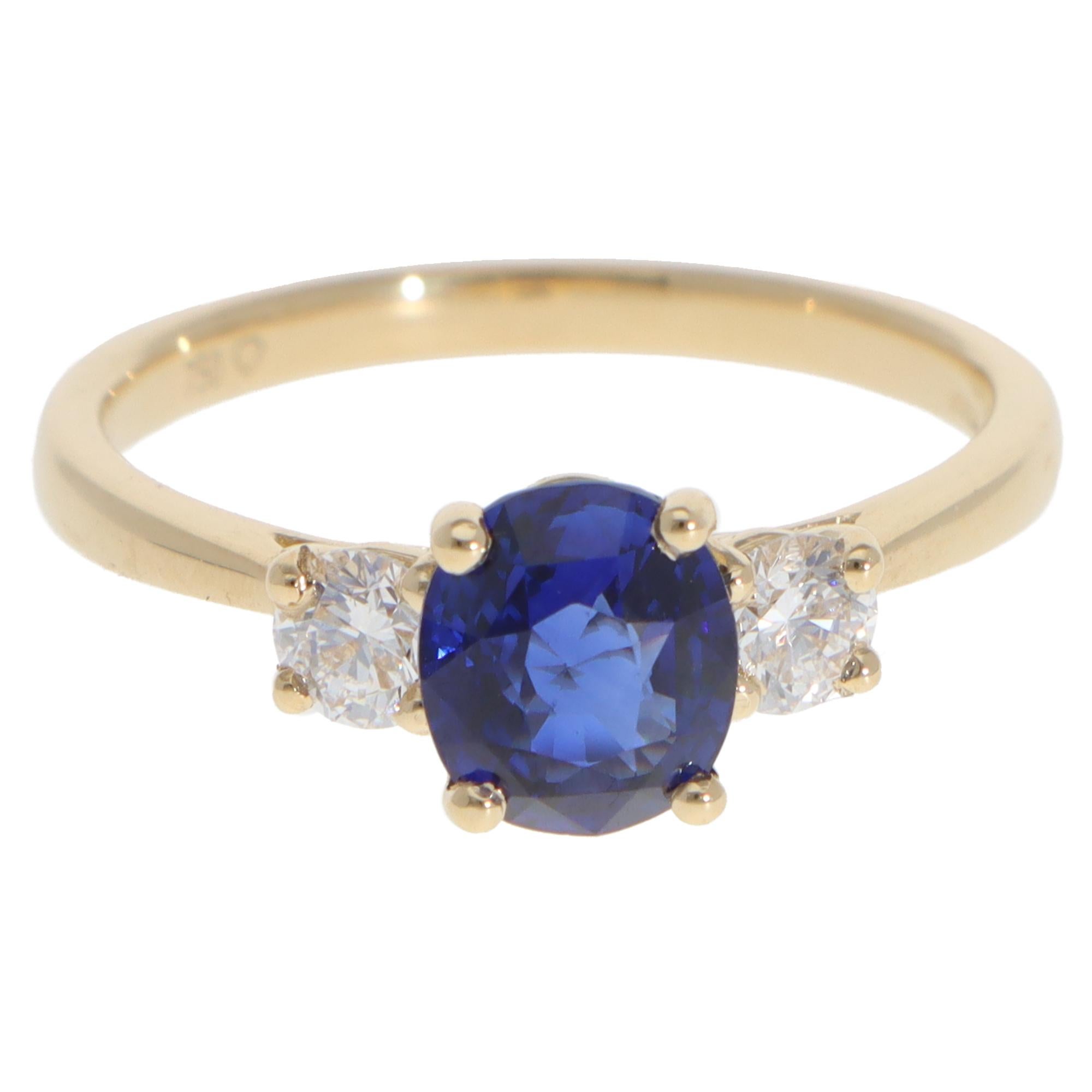 A beautiful contemporary sapphire and diamond three-stone ring set in 18k yellow gold.

The ring is composed of a central oval mixed-cut blue sapphire and 2 round brilliant-cut diamonds on the side. They are four-claw set securely and flow nicely to
