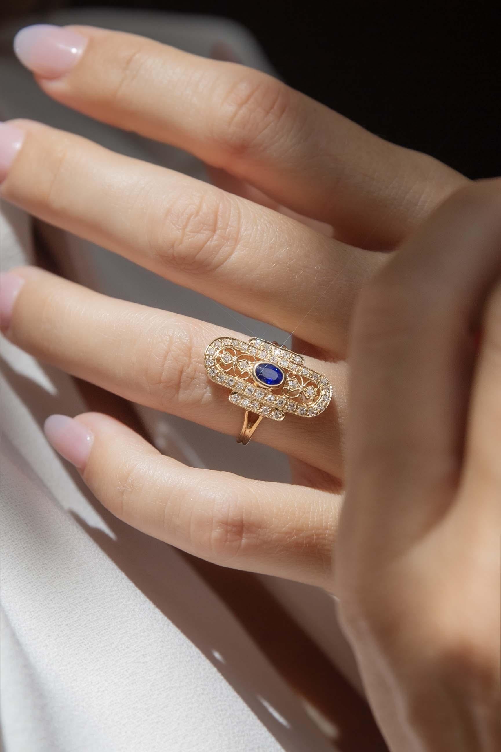 Una visione di eleganza vintage, l'anello Eira Sapphire & Diamond di ispirazione Art Deco in oro 18ct presenta un'intricata filigrana ornata da diamanti scintillanti. Nel suo cuore, uno zaffiro blu profondo irradia un fascino senza tempo, evocando