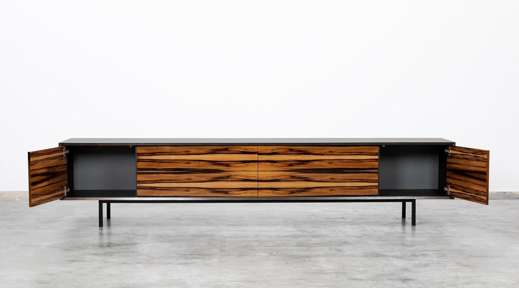 Sideboard by contemporary German artist Johannes Hock. The front of the doors and drawer of this unique piece are made of high-quality satin nut, the corpus is in black HPL on black metal legs. Manufactured by Atelier Johannes Hock.

Hock refined