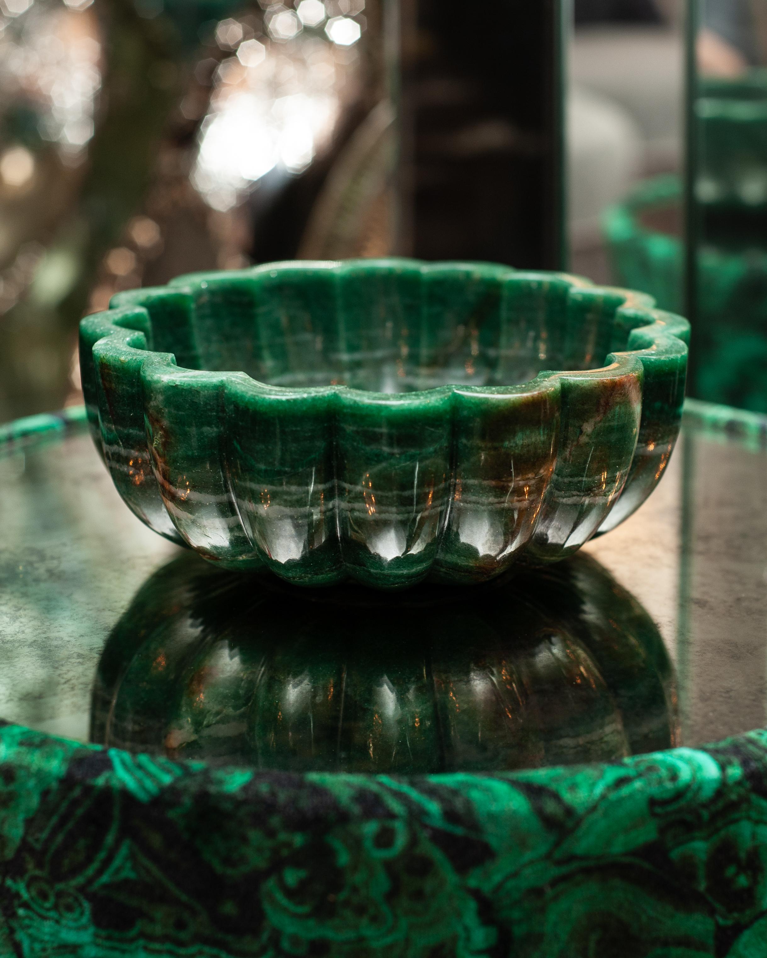 A large contemporary scalloped green aventurine bowl. Entirely carved by hand, this bowl started as a solid block of deep green stone, and through the master carvers work, the beauty and form are revealed. Aventurine is characterized by its rich