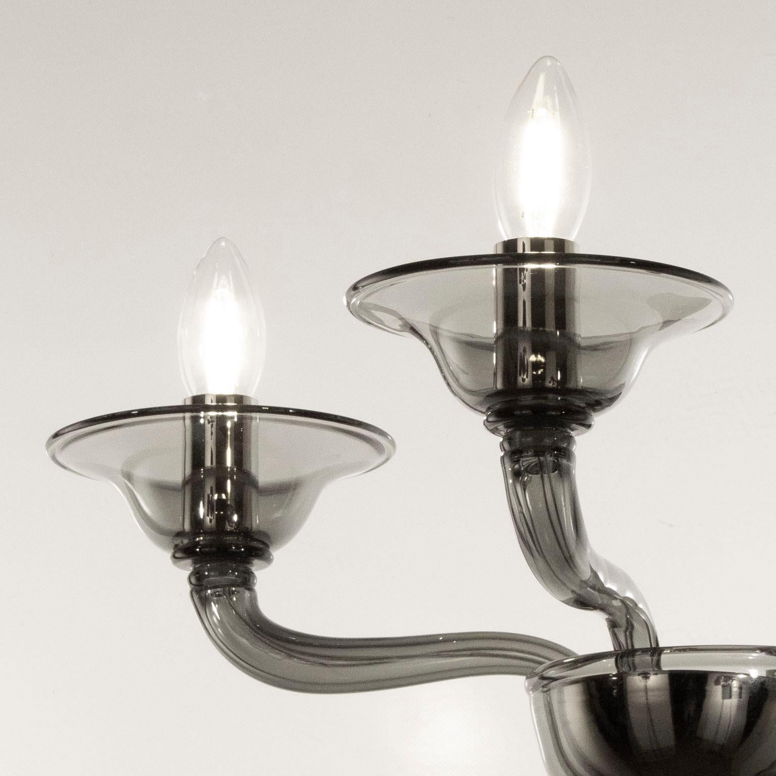 Multiforme Tobia sconce 2 lights. Smooth dark grey Murano glass with castle arms climbing arms.
The blown glass chandelier and sconces Tobia hark back to the design typical of the first half of the 20th century.
This lighting work is characterized