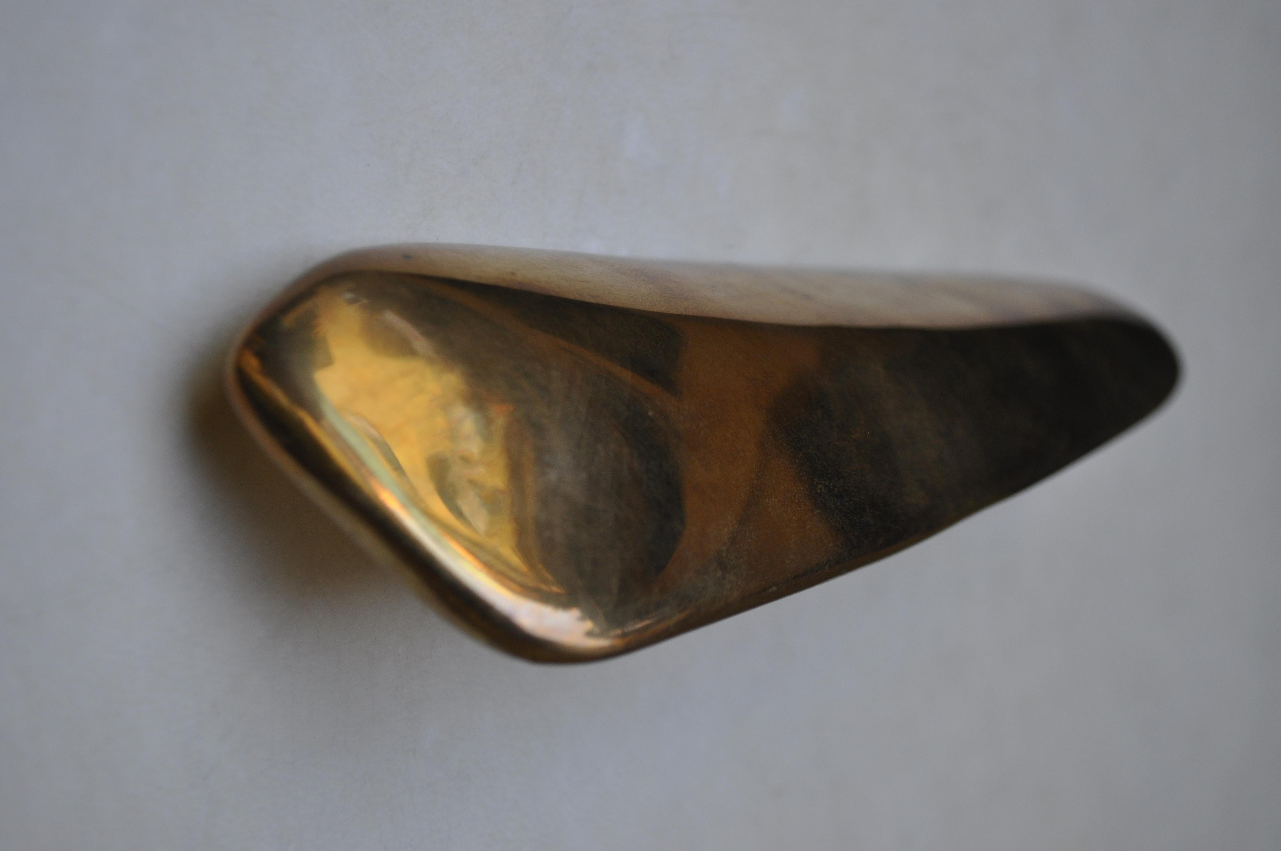 Small shiny sculpture that evokes vegetal and marine forms, smooth to the touch and made in bronze casting, according to the ancient technique of French sand molds. This handles are a sculptural touch for closets, doors or drawers.