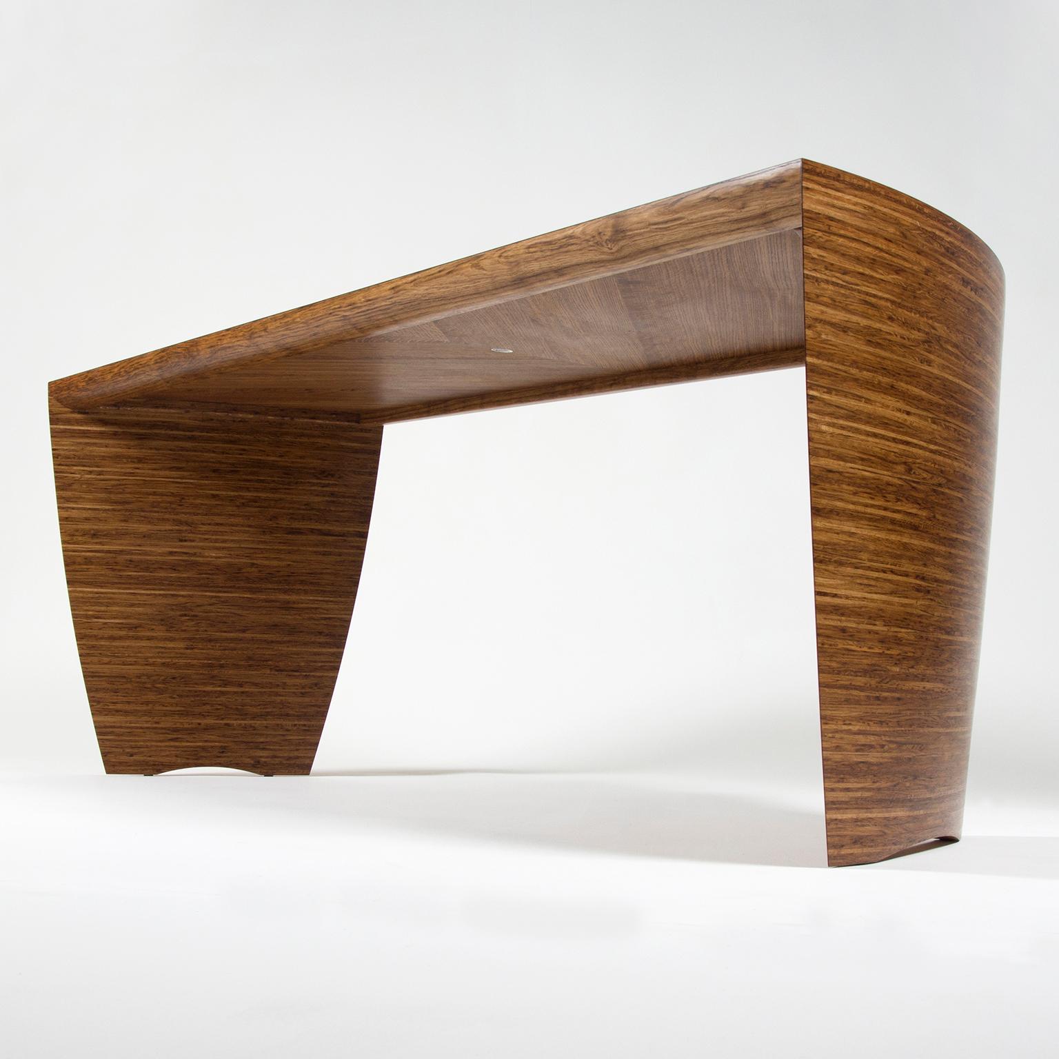 The contemporary curved and sculptural ‘Radiant’ desk by Edward Johnson is made in fumed oak and brown oak with an oiled finish. 

The top of this stunning desk starts with a small semi-circular fumed oak centre, that flows seamlessly from the