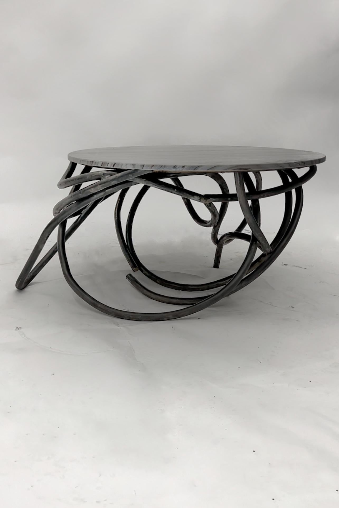Designed and crafted in downtown Los Angeles by Dieppa Design. 
Built from solid 1” thick steel rods and a unique heavily veined marble slab. 

A Unique viewing experiences from every angle. 

Marble top: 34.5” 
Height: 18 3/4”
Base undulates from