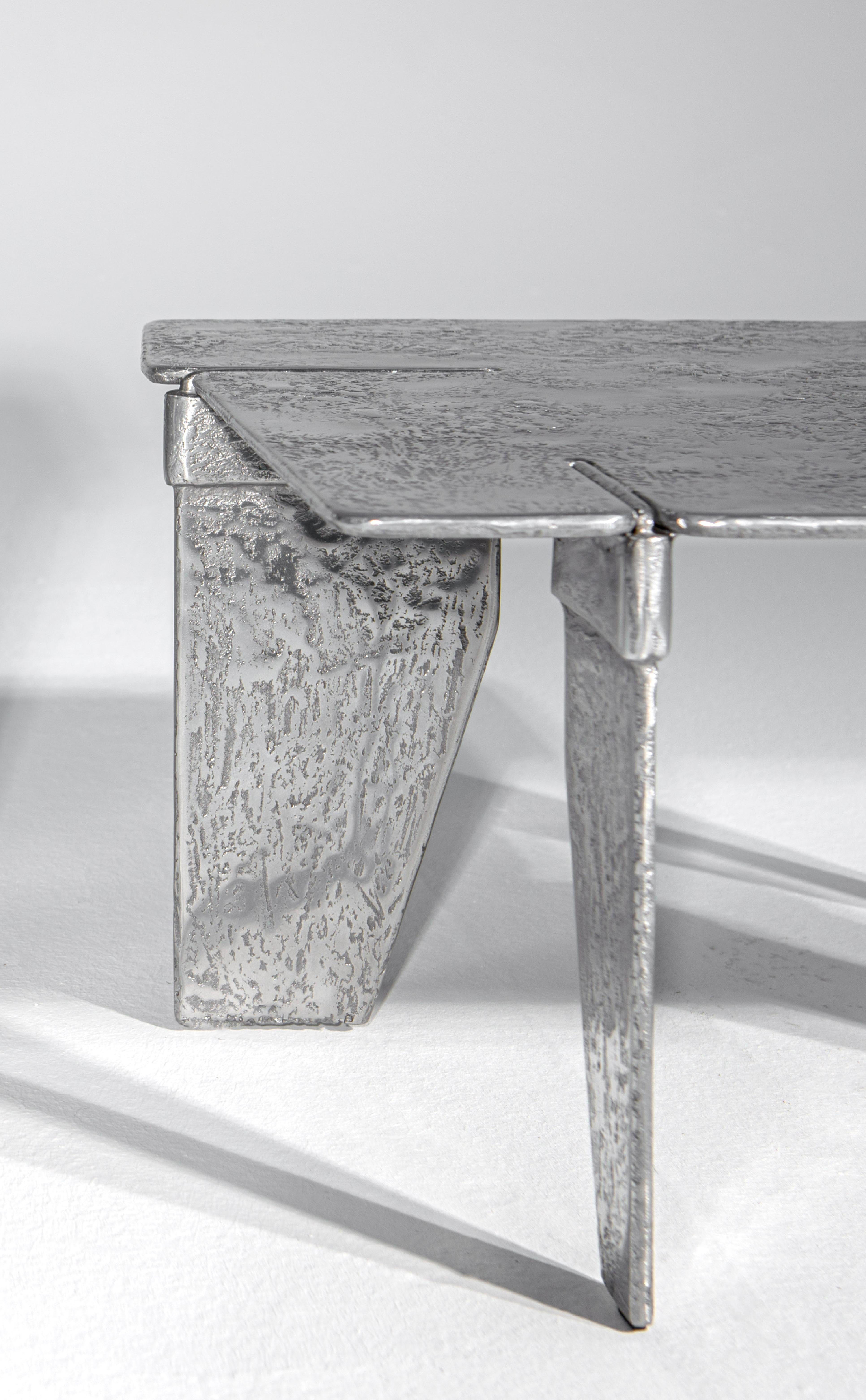 La table basse Overlap est entièrement fabriquée en aluminium. Il est obtenu en coulant l'aluminium dans des moules spéciaux en sable. L'aspect sculptural de la surface et l'utilisation du métal comme matière première font de cet article une œuvre
