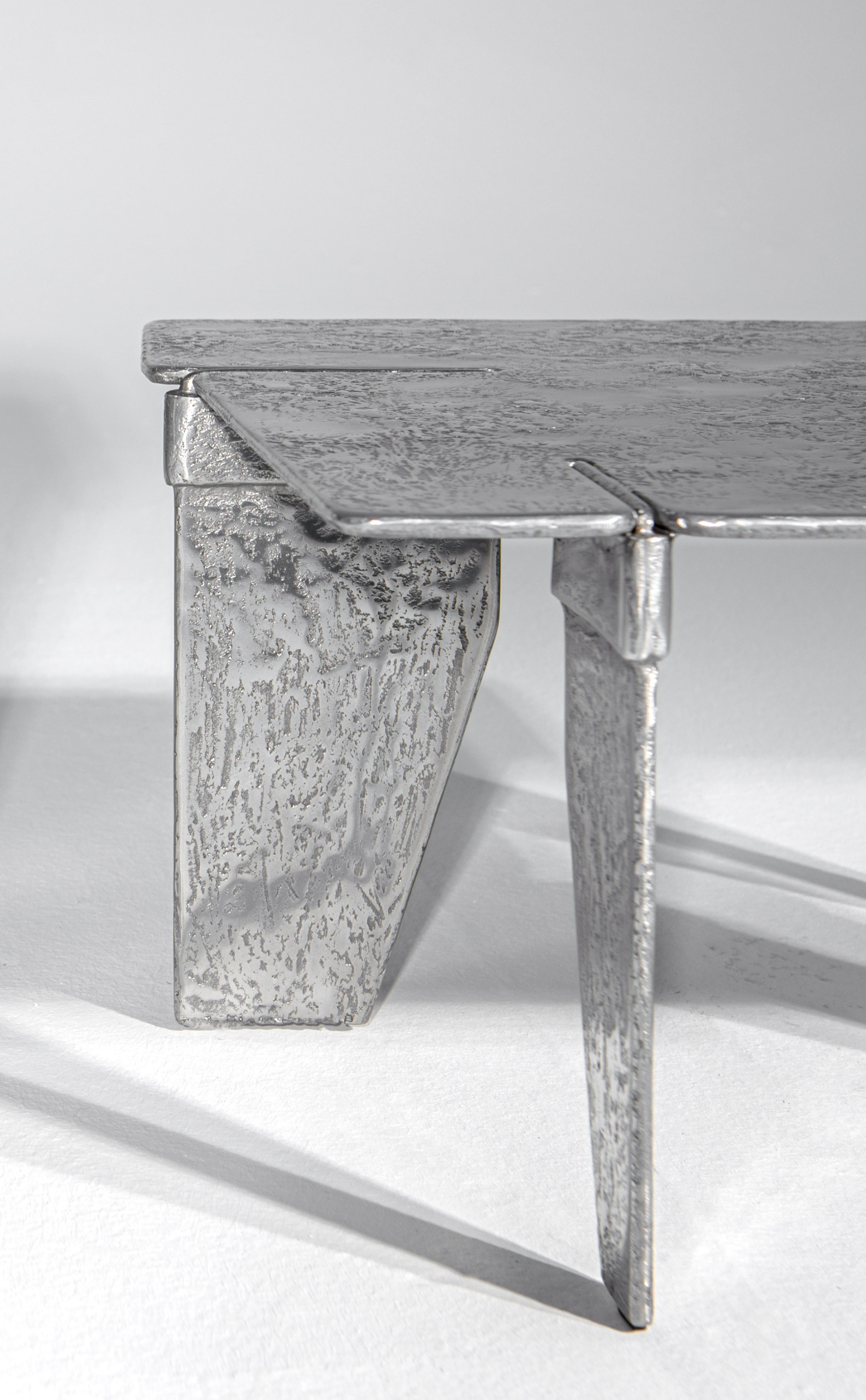 Der Couchtisch Overlap ist komplett aus Aluminium gefertigt. Es wird durch Gießen des Aluminiums in spezielle Formen aus Sand gewonnen. Das skulpturale Aussehen der Oberfläche und die Verwendung von Metall als Rohmaterial machen diesen Gegenstand zu