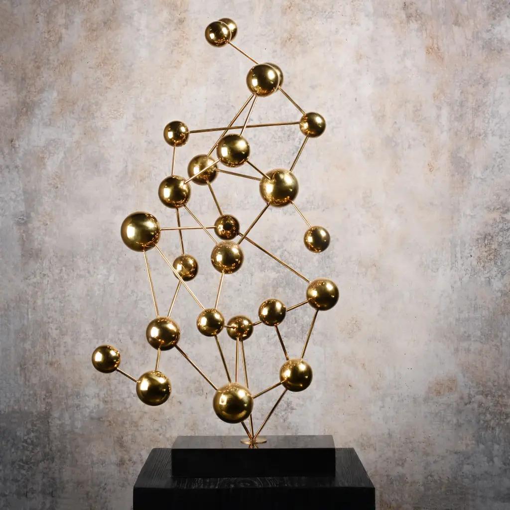 Zeitgenössische Skulptur aus vergoldeter Bronze, montiert auf einem Sockel aus schwarzem Marmor. Sie erinnert an organische und geometrische Formen, die von der Natur inspiriert sind. Der Kontrast zwischen der vergoldeten Bronze und dem schwarzen