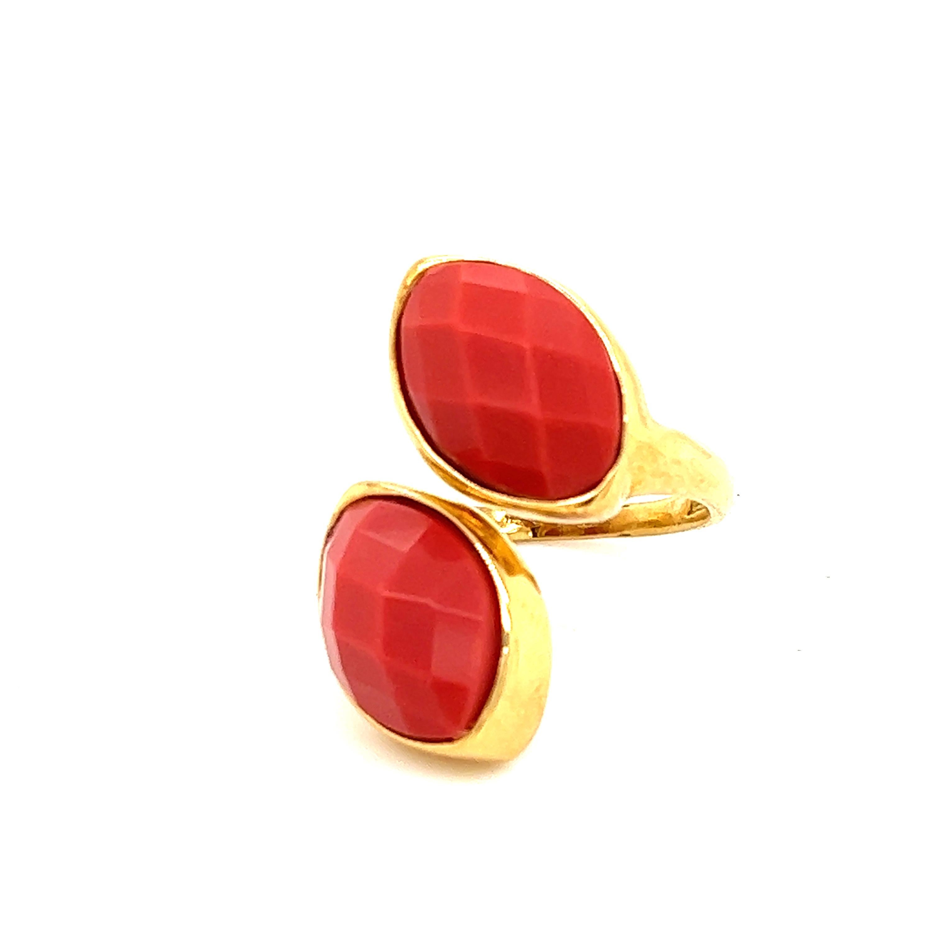Trendy design seen on this 18k contemporary design. The ring is crafted in 18k gold and is the form of a serpent. The ring is set with two checkerboard cut coral color gemstones. The gemstones are of synthetic variety. The ring is a by-pass design