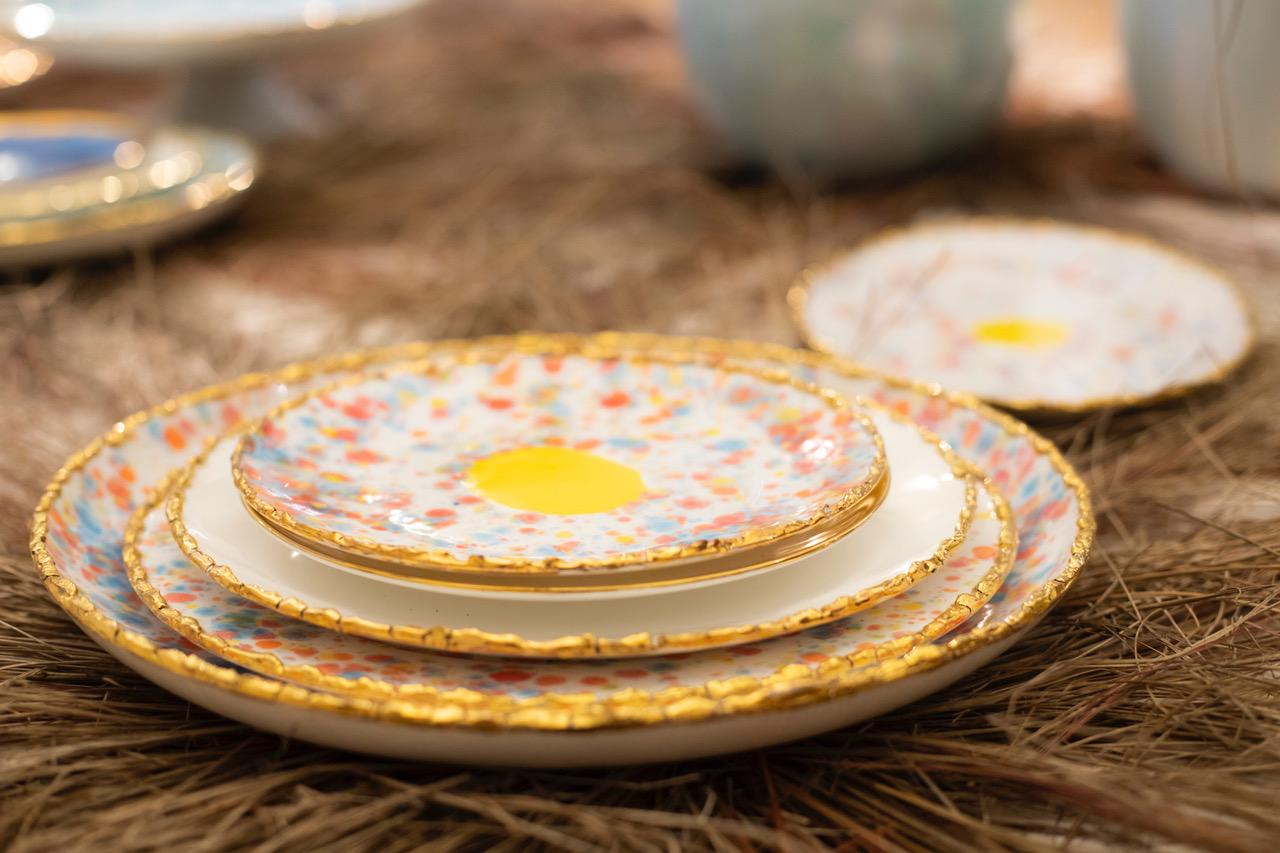 Handcrafted in Italy from the finest porcelain, these Craquelé edge dessert coupe plates from the Confetti Collection have a unique golden crackled rim emphasizing the lively multi-color dotted enamel decoration and the Classic large yellow dot at
