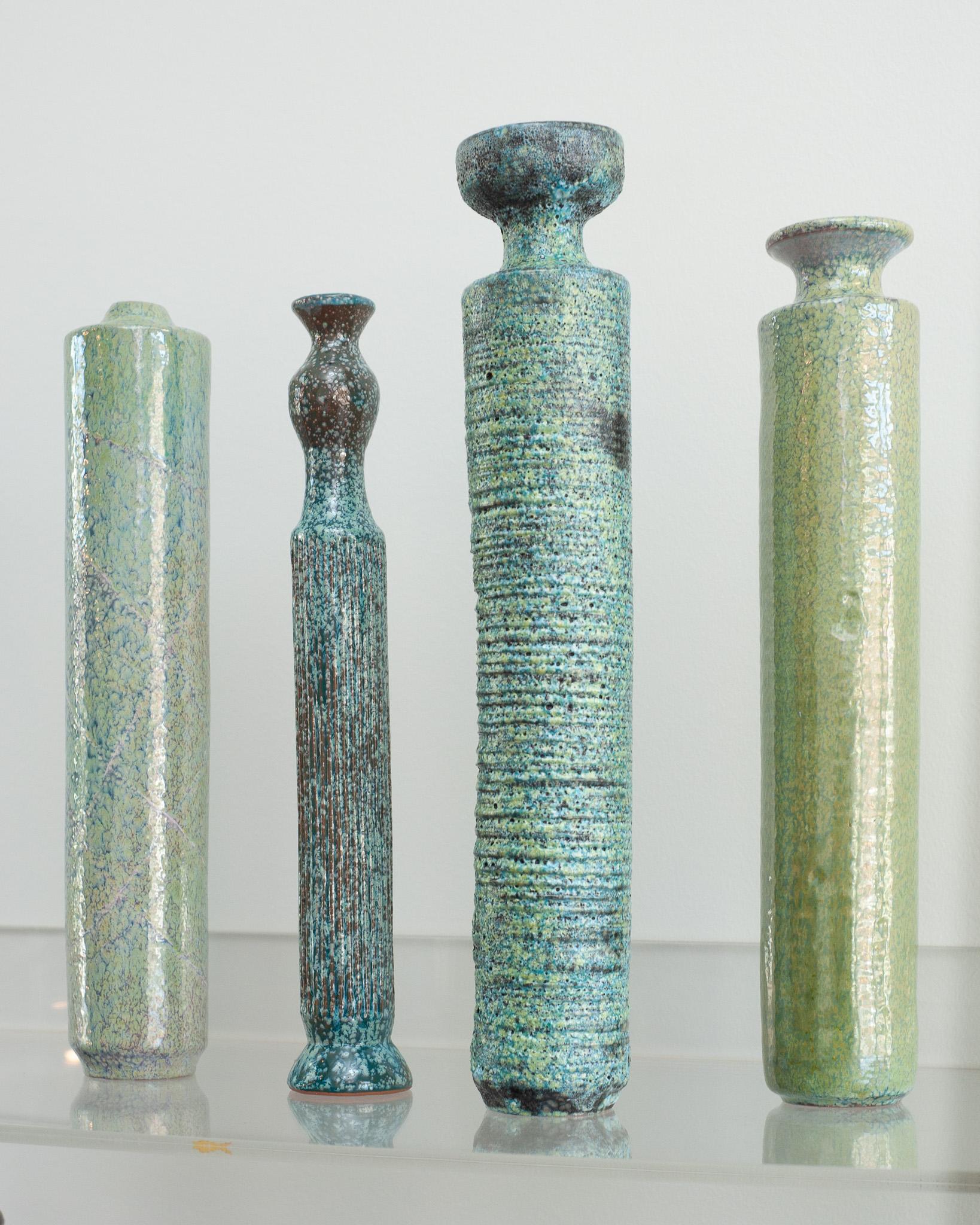 Uno splendido set di 4 vasi in ceramica smaltata in stile metà secolo. Ognuno di essi è unico per forma e finitura ed è firmato dall'artista. Eleganti e insoliti, questi pezzi formano un gruppo armonioso per elevare qualsiasi spazio interno con