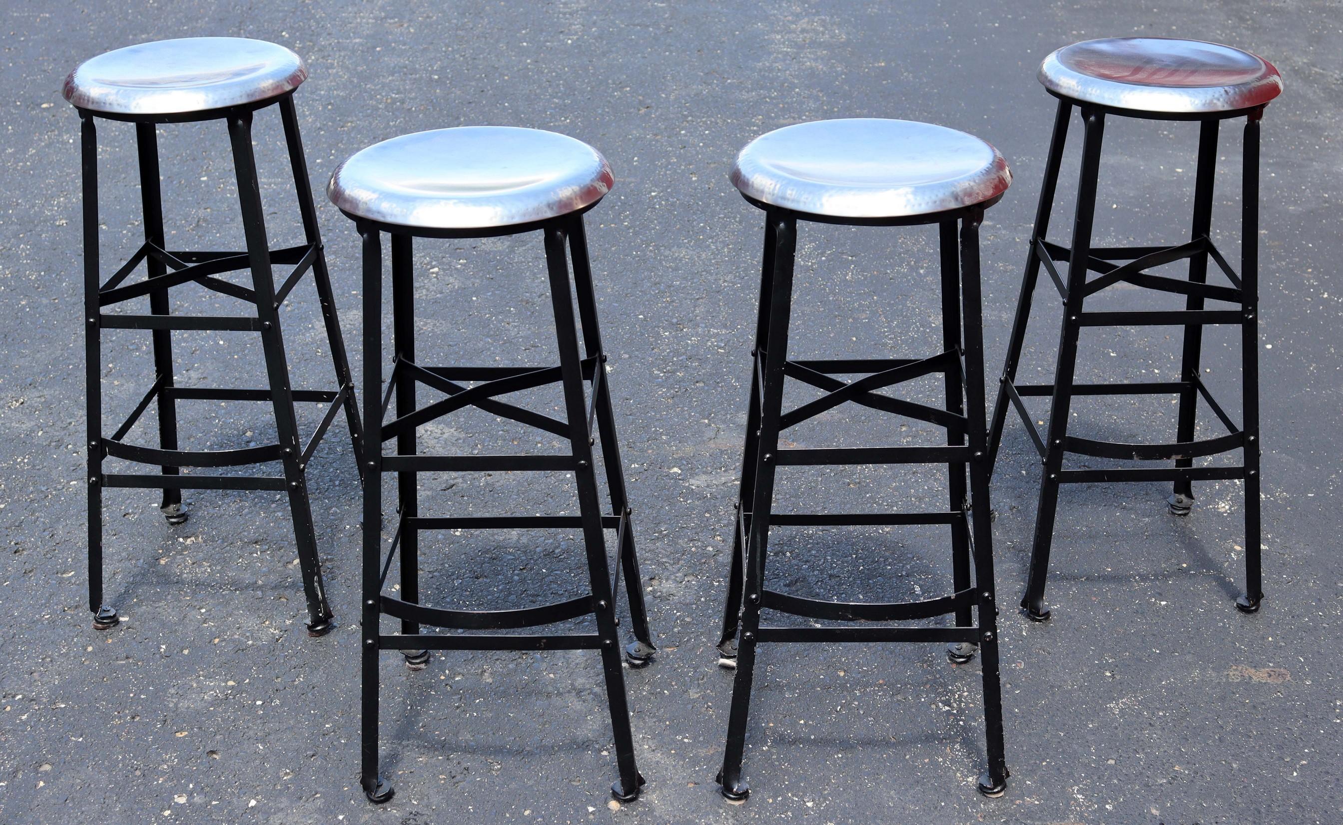 For your consideration is a minimalist set of four bar or counter stools, with black painted metal bases and chrome finish seats. In good condition. 14