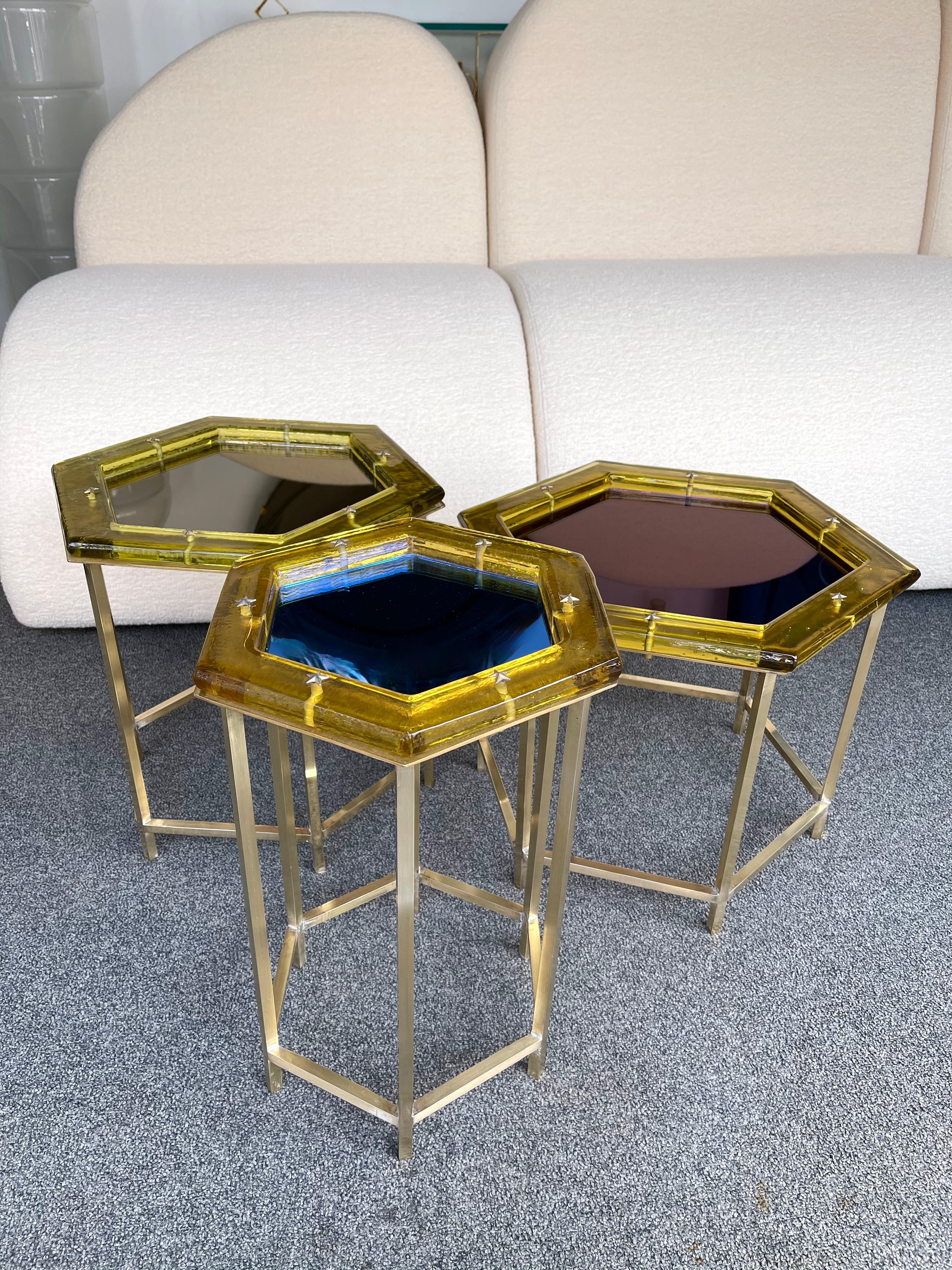 Set of Nesting nested tables or coffee low cocktails side end tables in brass, yellow Murano glass and bronze, purple and blue mirror top. Nice brass stars details. Small artisanal production from an italian workshop. In the mood of Maison Jansen,