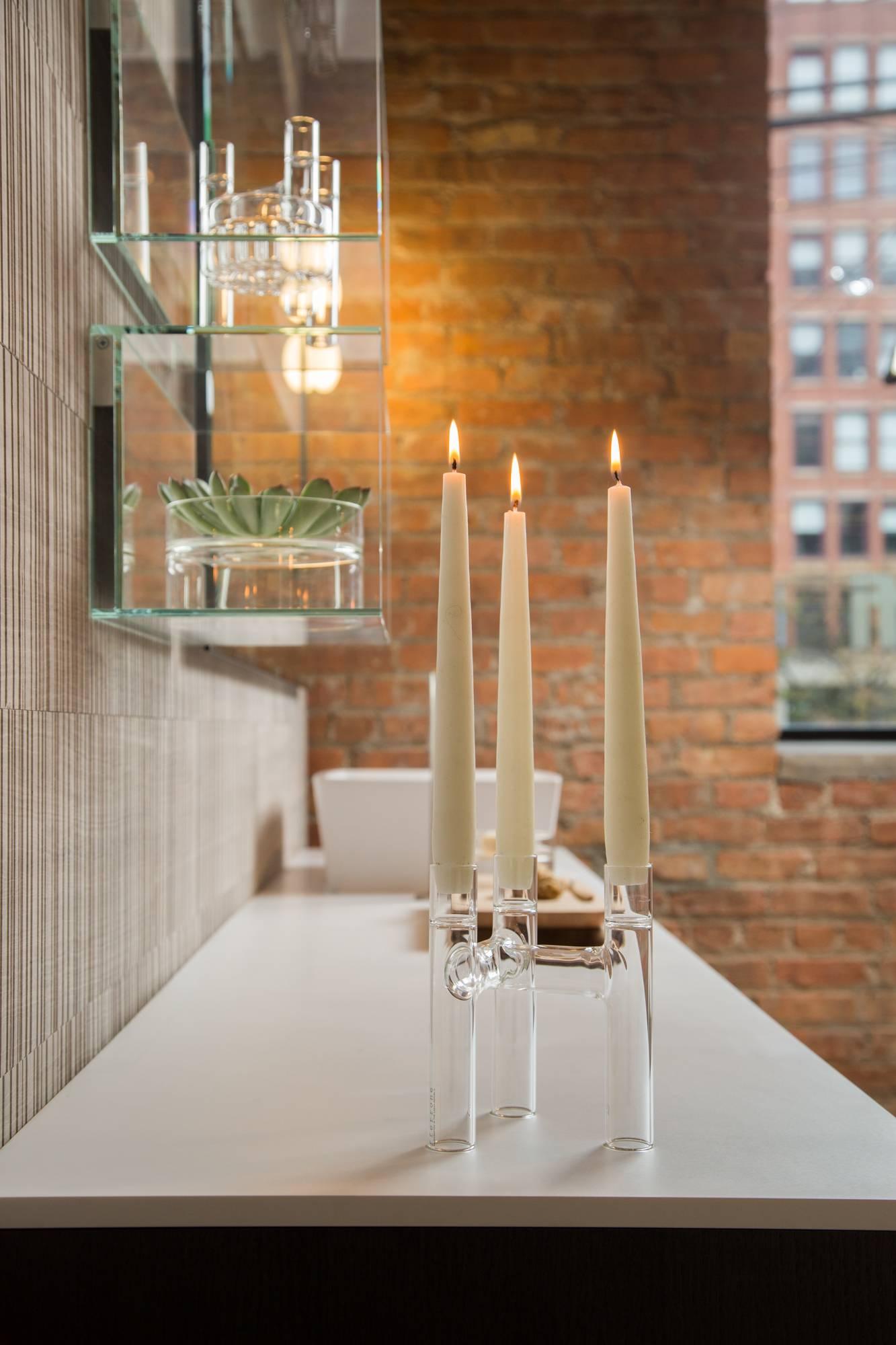 L'ensemble contemporain de deux candélabres Trio en verre clair, fabriqué à la main, peut servir de candélabre ou de vase à bourgeons. Utilisé en multiples, il permet de créer des arrangements ludiques à l'infini et d'inspirer l'imagination. La