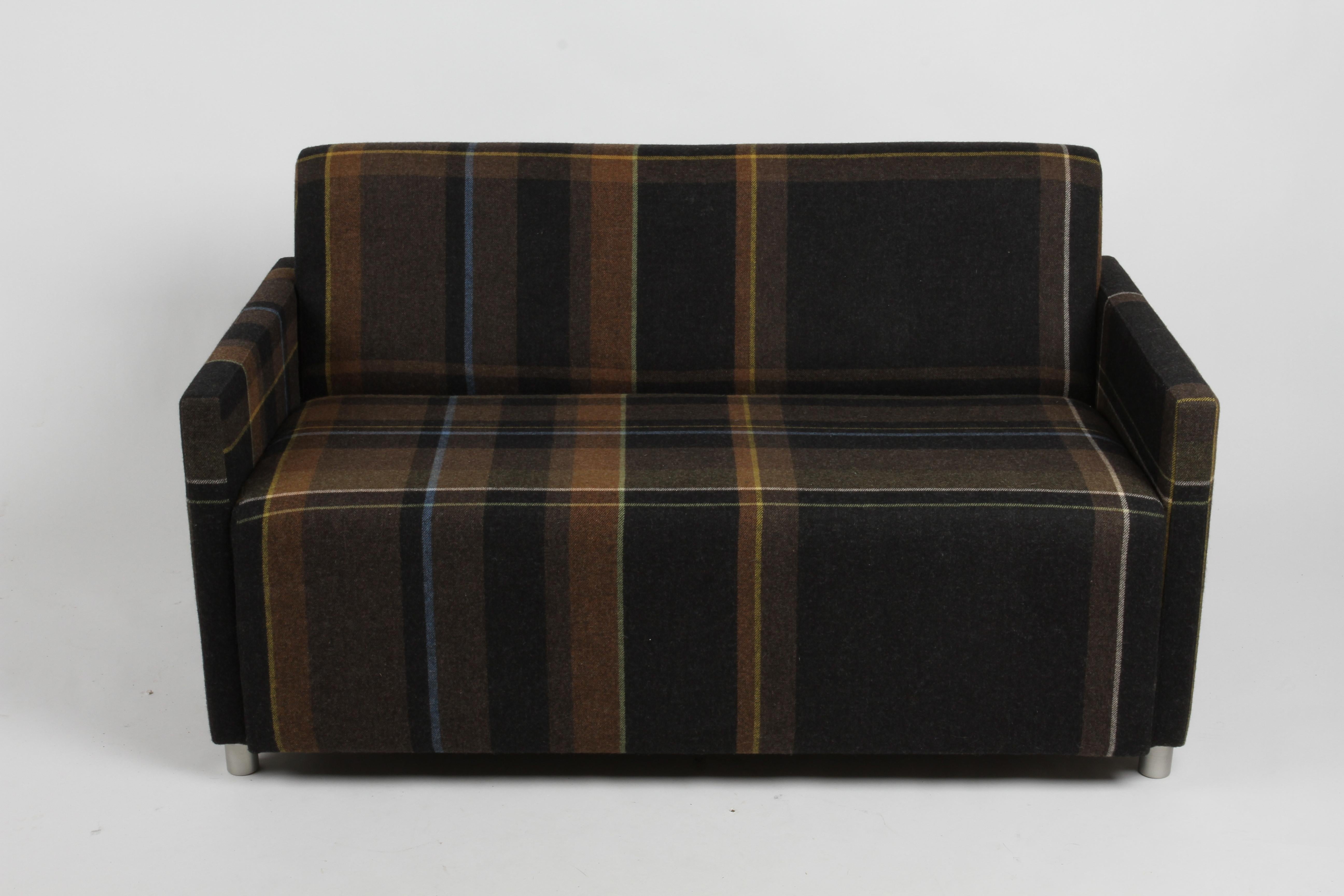 Contemporary loveseat or settee with sleek lines on round metal legs, this Coupe Tuxedo sofa designed Dennie Pimental and John Duffy for Coalesse. Beautifully upholstered in Paul Smith by Maharam UK, the exaggerated Plaid pattern, 100% wool,