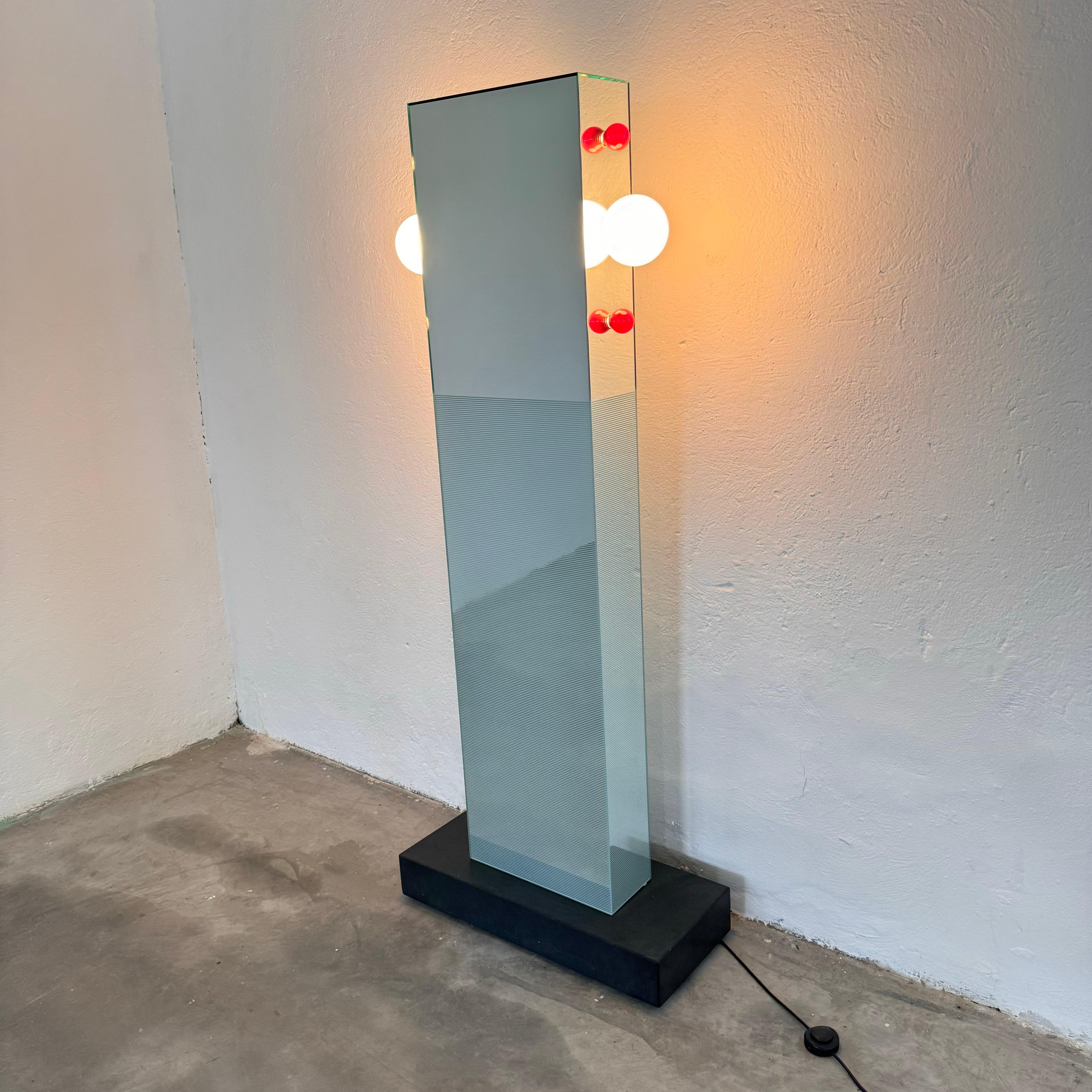 Un omaggio alle iconiche torri della storica città murata di Shibam, nello Yemen, questo specchio totem di Ettore Sottsass Jr. è un elemento accattivante per qualsiasi interno. Il design dello specchio si ispira alla suggestiva architettura