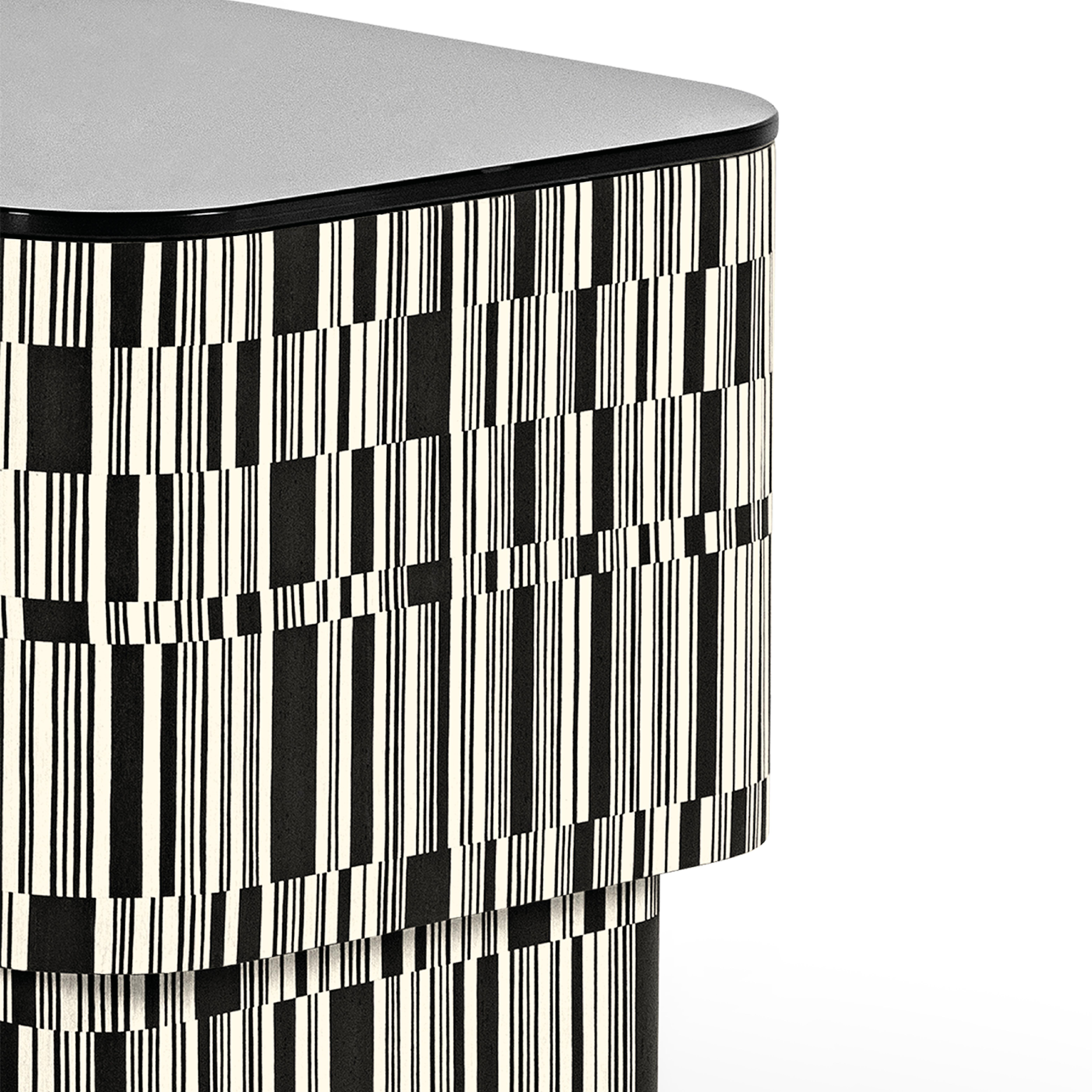 La structure de la table d'appoint Enigma est revêtue de bois, traité avec une incrustation en fil croisé avec des nuances blanches et noires qui s'alternent de manière irrégulière. Il présente une finition Matrix mate et un plateau en verre noir.