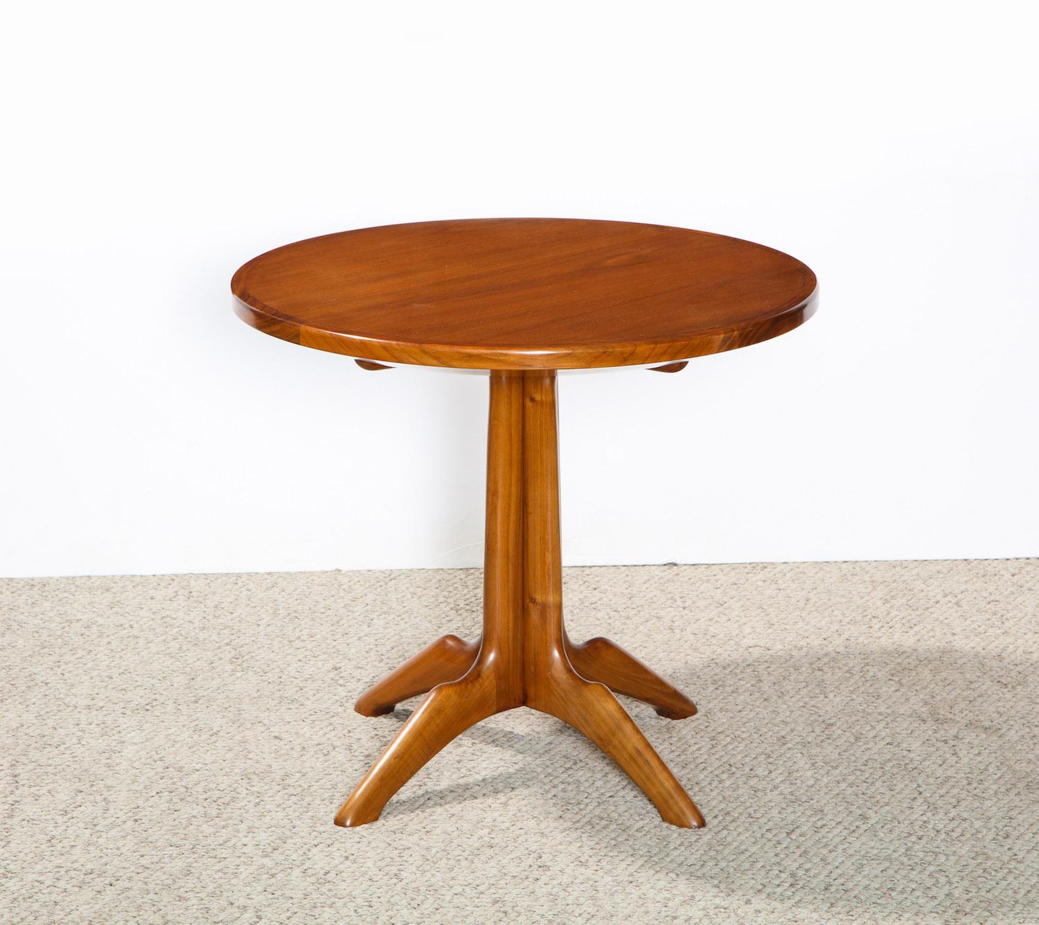 Pedestal table of Italian walnut with 4 carved legs and circular walnut top. Based on an anonymous vintage design with a fantastic sculptural base.