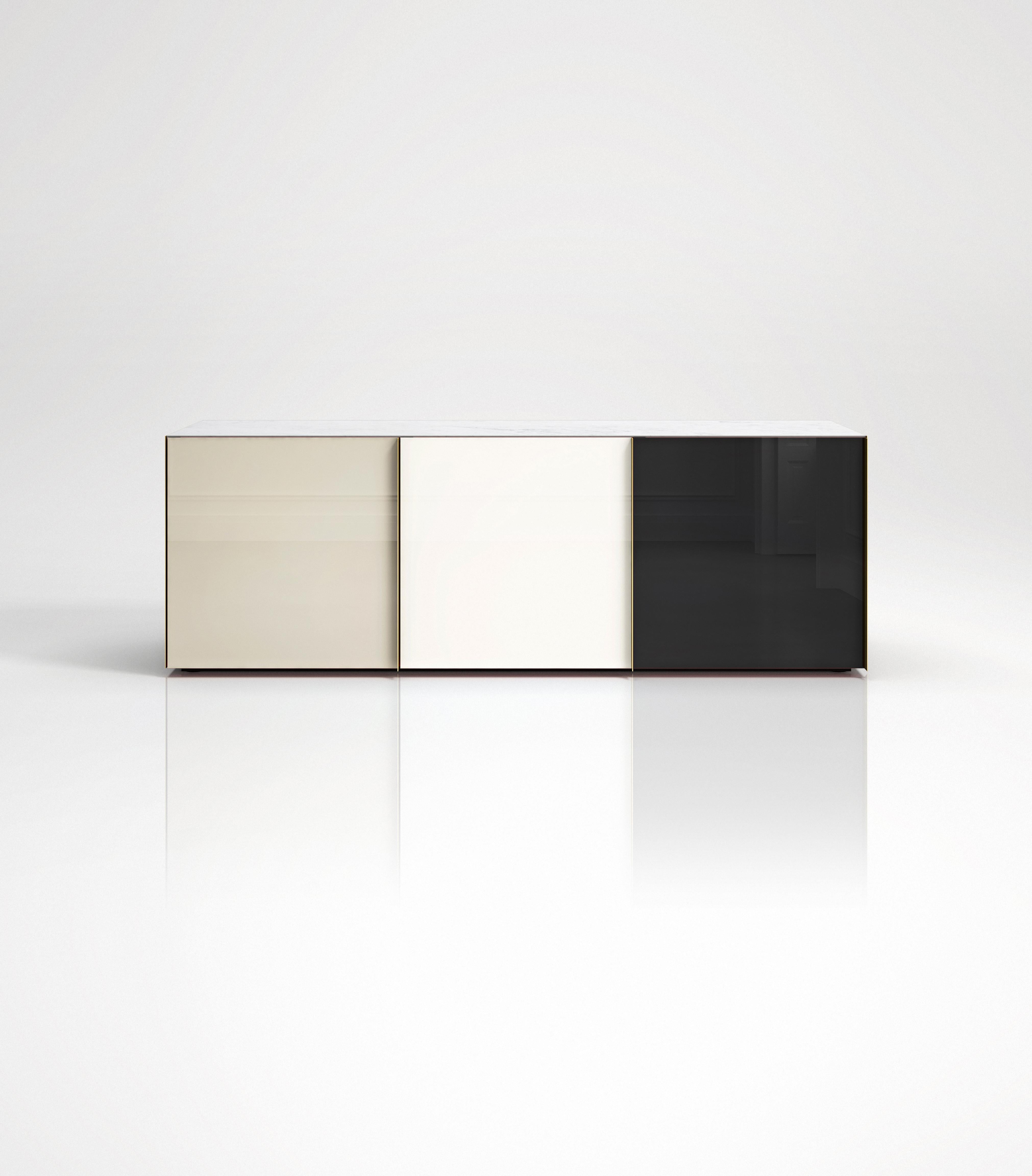 Sideboard 01
Sideboard featuring 3 back-painted glass doors colored in neutral tones, Carrara marble top, lacquered wooden interior and brass handles and side panels. Each of the three compartments has an internal glass shelf. It can be placed in
