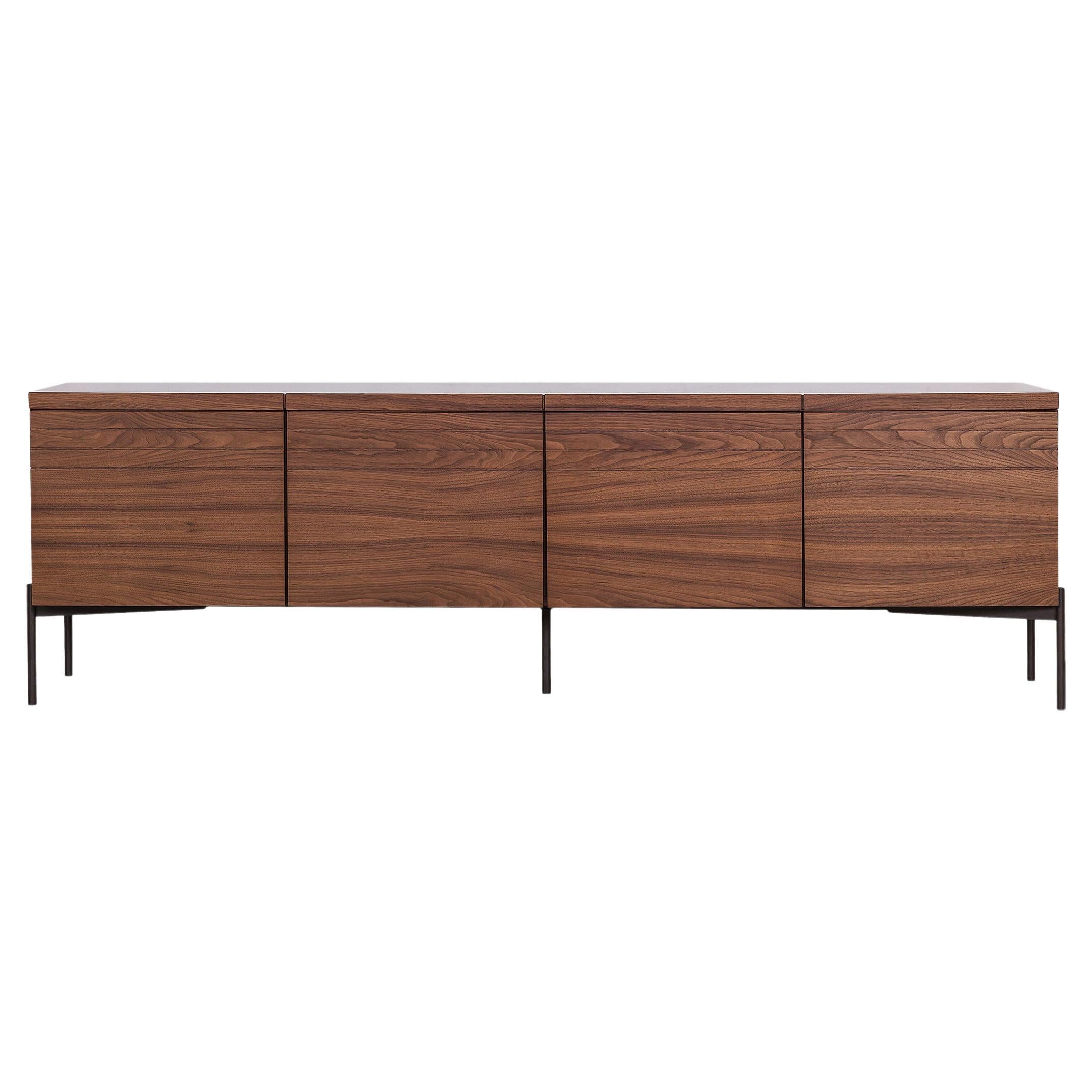 Dining room sideboard characterized by simplicity with attention to detail. The horizontal lines carved around the cabinet along with the simple metal base, give the sideboard a more elegant dimension. The sideboard has four push-pull doors and an