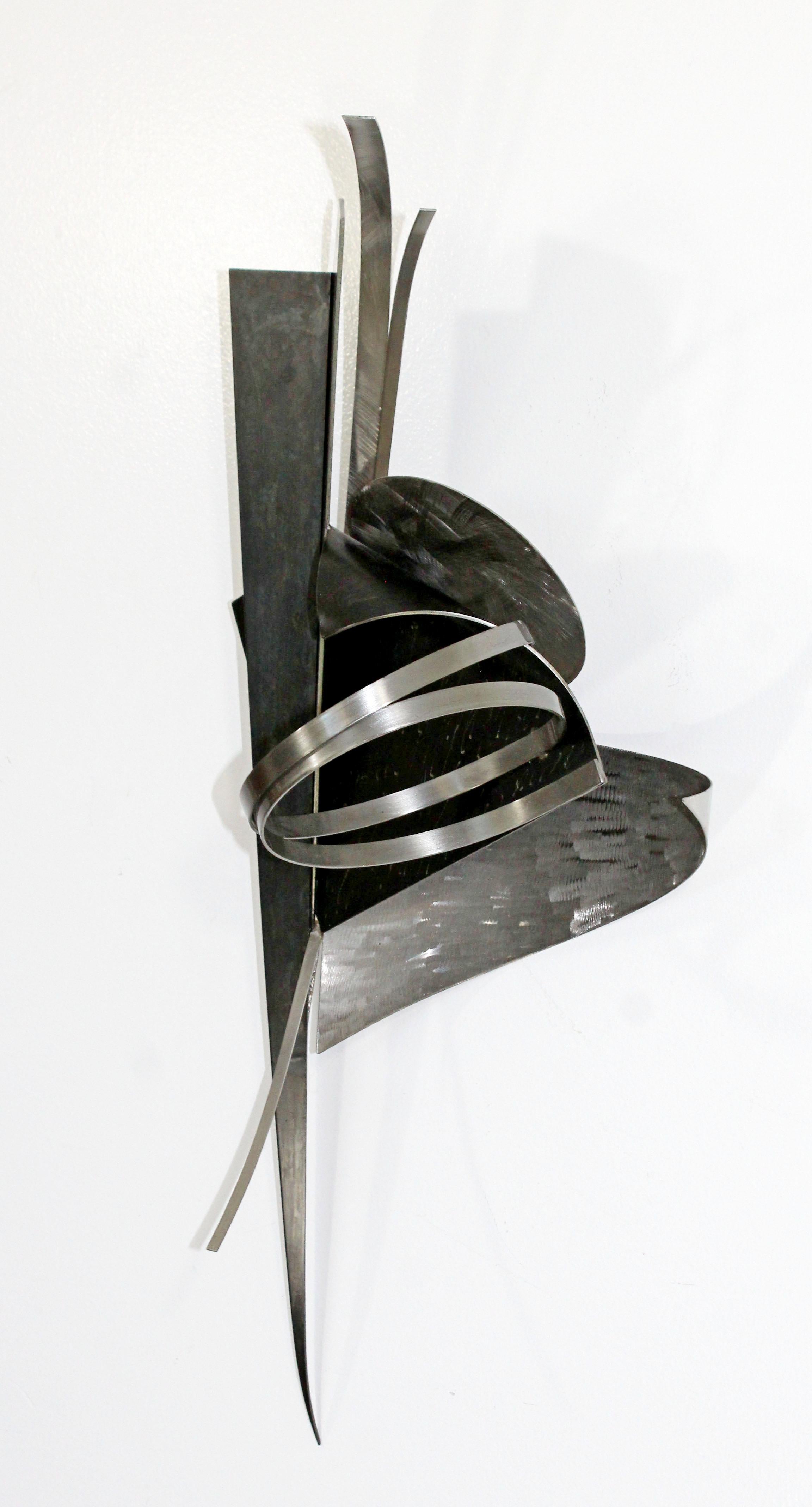 For your consideration is a stunning, abstract, steel and mixed metal wall sculpture, signed and dated by Christiane T. Martens, circa 1994. In excellent condition. The dimensions are 13