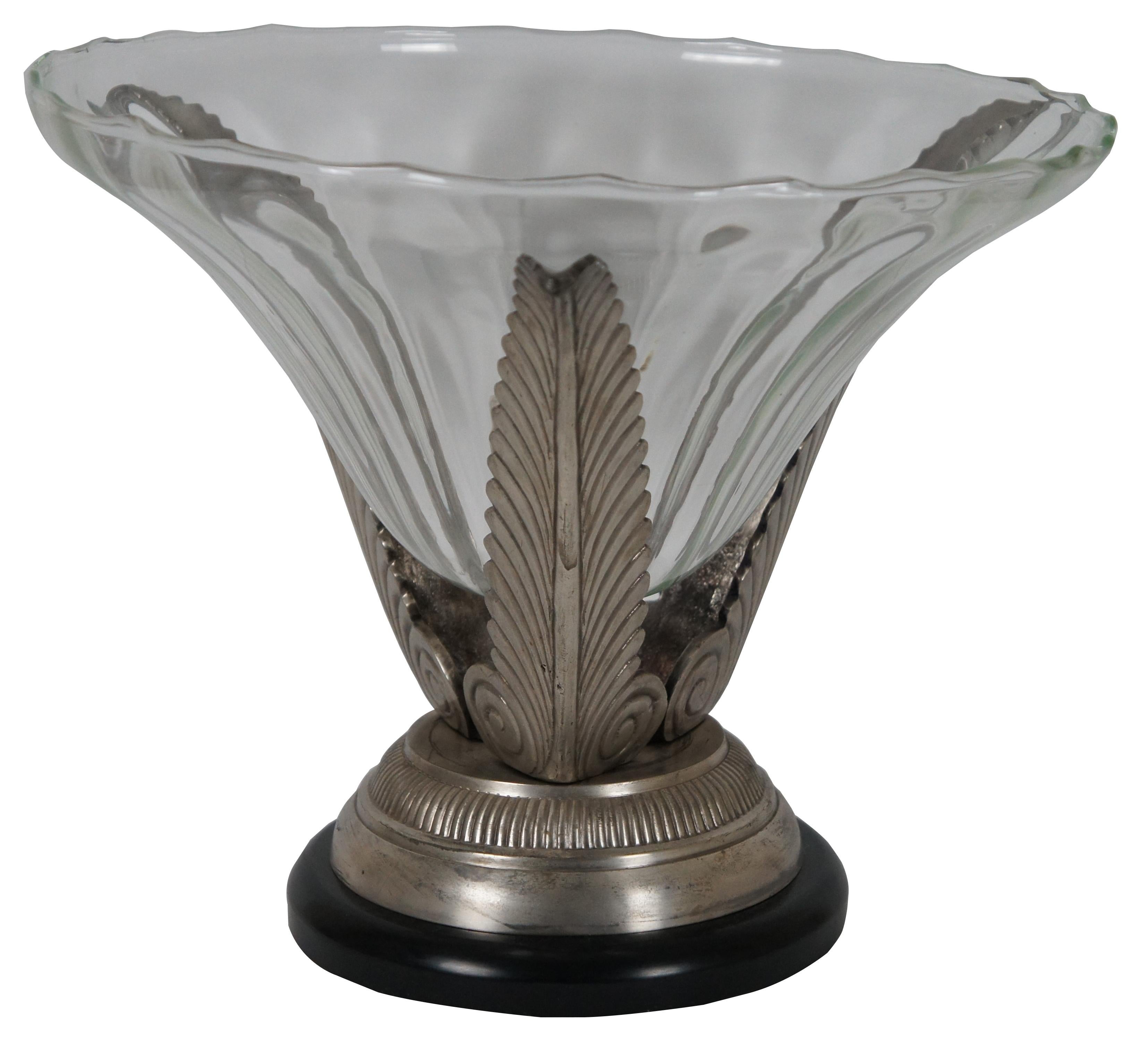 Hand crafted glass centerpiece bowl gently rippling texture, standing on a trio of silver painted metal acanthus leaves on a silver and black pedestal base.