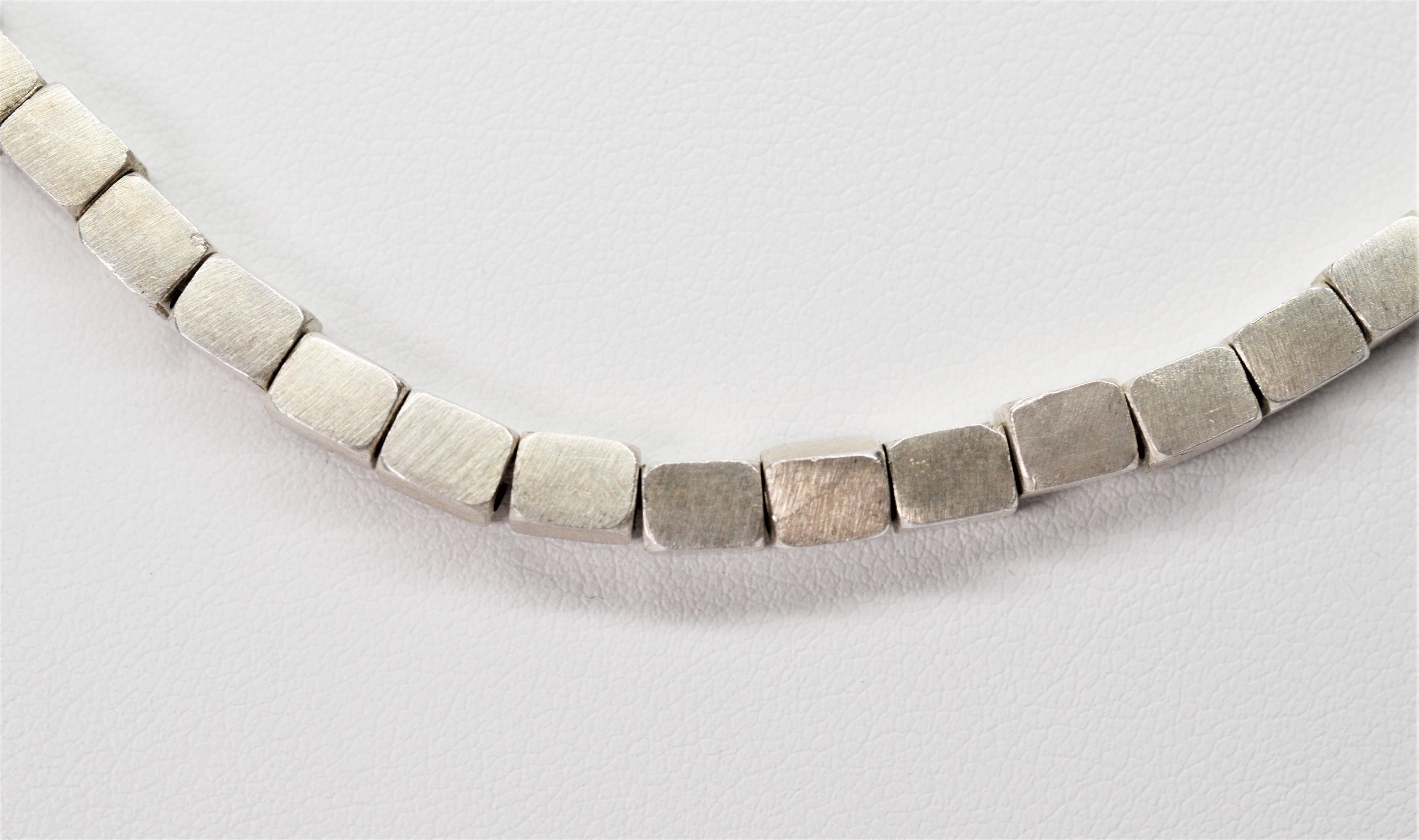 This on-trend sporty necklace from Switzerland is made of sixty five individually hand strung satiny .970 silver block beads.  At sixteen inches in length, it sits perfectly at the collar to add a dash of sophistication to a tee shirt or a playful