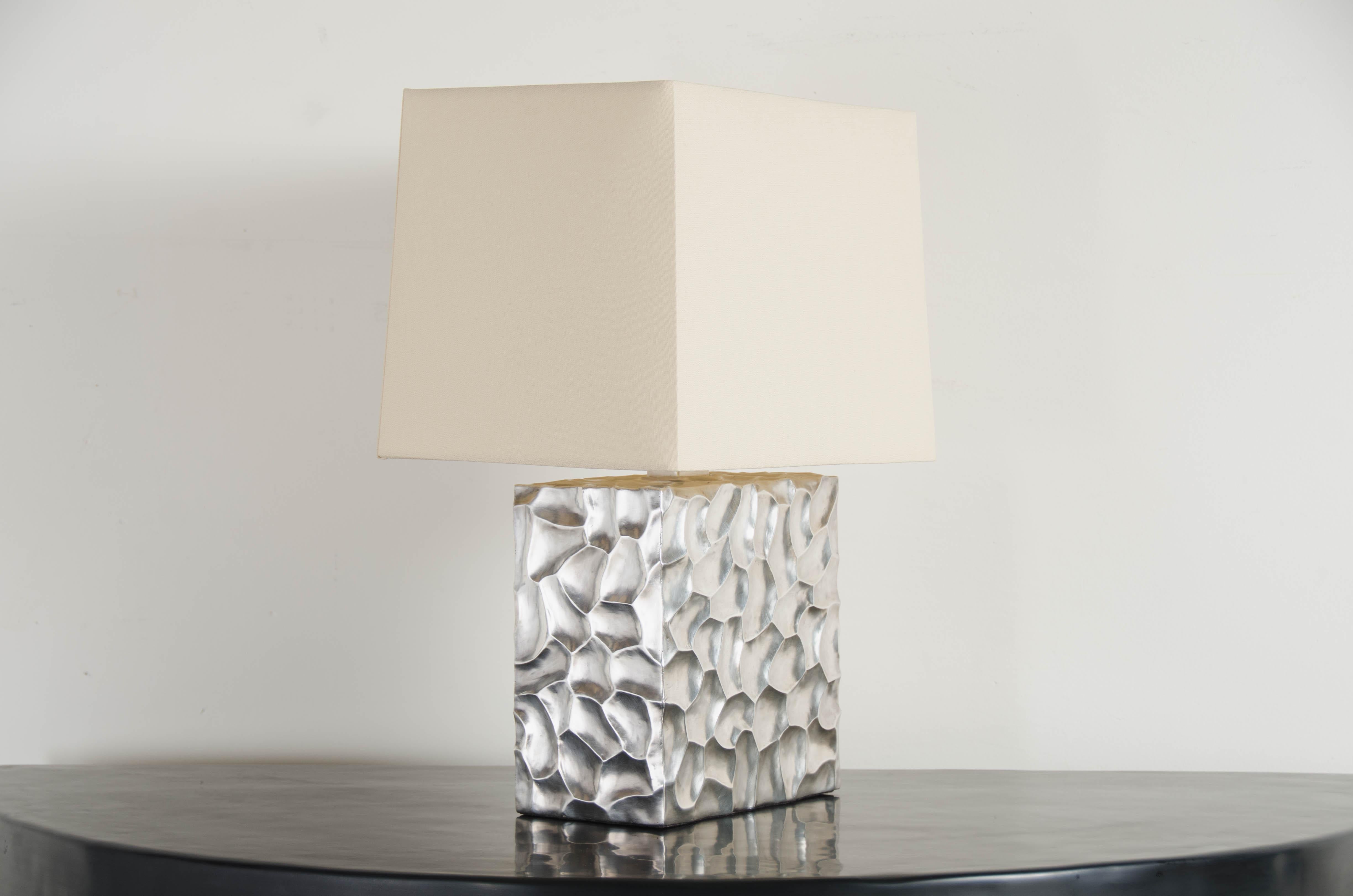 Rocco cube table lamp
Silver plated
Copper base
Hand repoussé
Limited edition
Natural linen shade
Each piece is individually crafted and is unique. 
Repoussé is the traditional art of hand-hammering decorative relief onto sheet metal. The