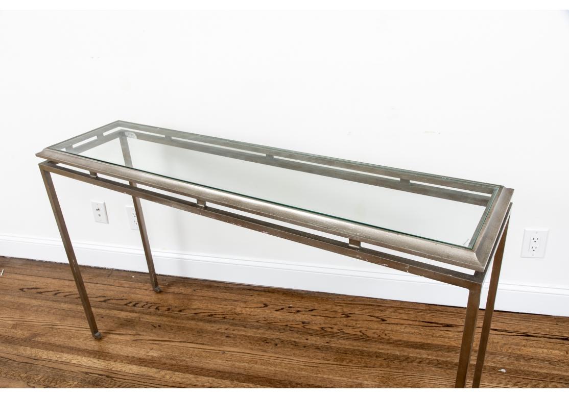The elegant Minimalist console table with tiered frame- a top curved one in silver gilt wood mounted on a silvered metal frame. Raised on legs with incurved feet. With an inset glass top. 
Measures: L. 54
